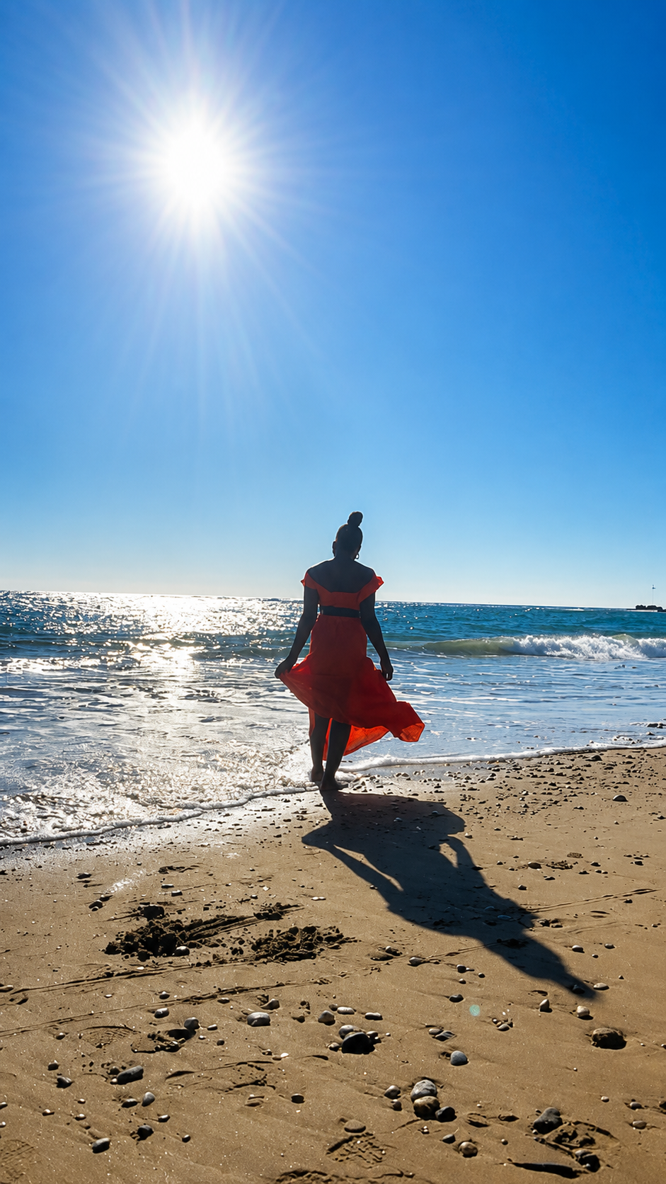 A peaceful figure standing by the sea in bright sunlight