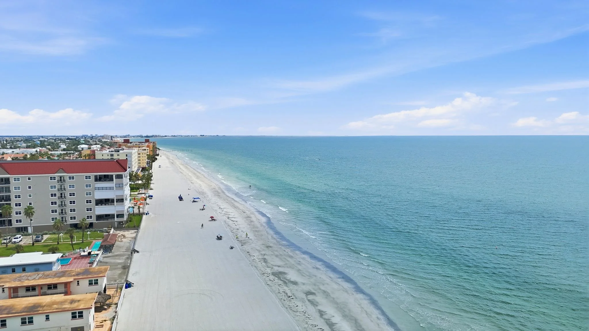 Aerial view of the Gulf shoreline with beach umbrellas and swimmers at North Redington Beach