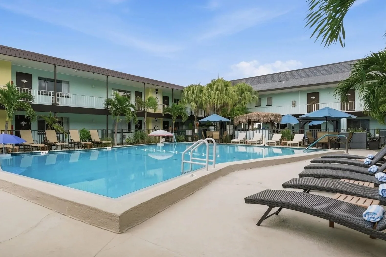Outdoor pool with lounge chairs and fresh towels in the palm-lined courtyard, North Redington Beach