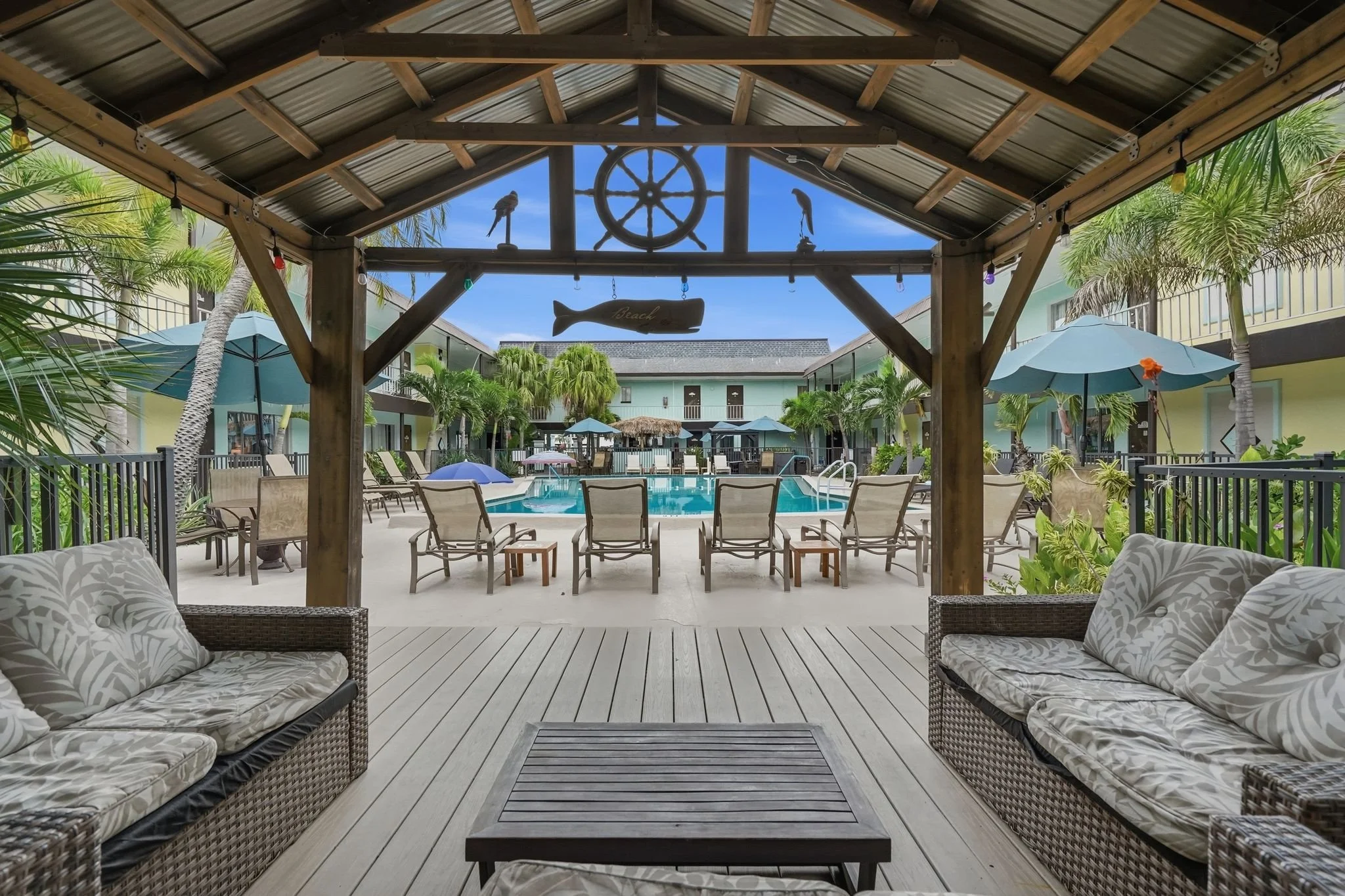 Shaded poolside cabana with lounge seating overlooking the courtyard pool, Island House Resort Hotel