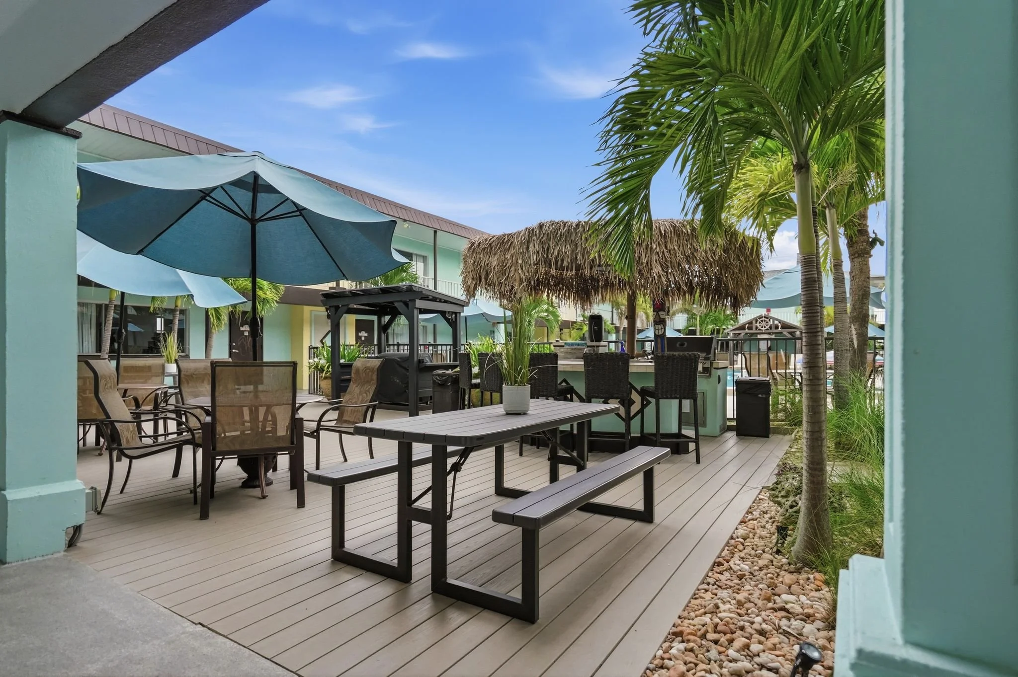 Shaded poolside deck with picnic tables and outdoor dining seating at Island House Resort Hotel