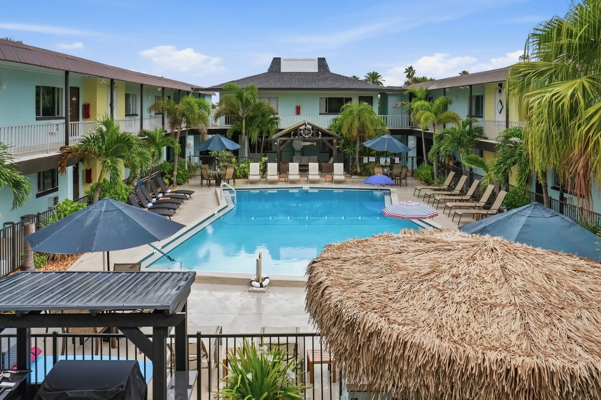 Elevated view of the courtyard pool surrounded by guest room balconies, Island House Resort Hotel