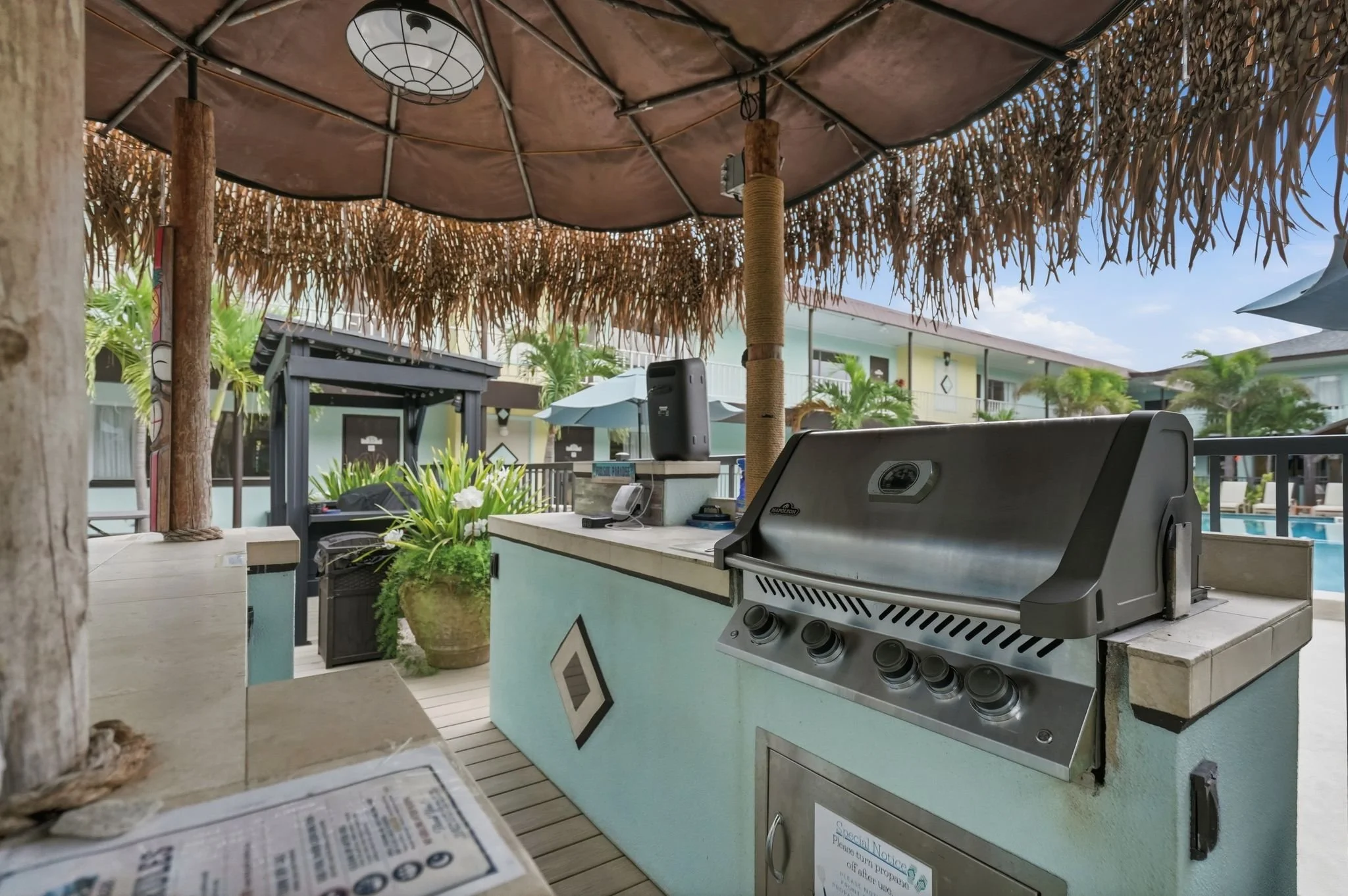 Poolside tiki bar with built-in gas grill under a thatched roof, North Redington Beach