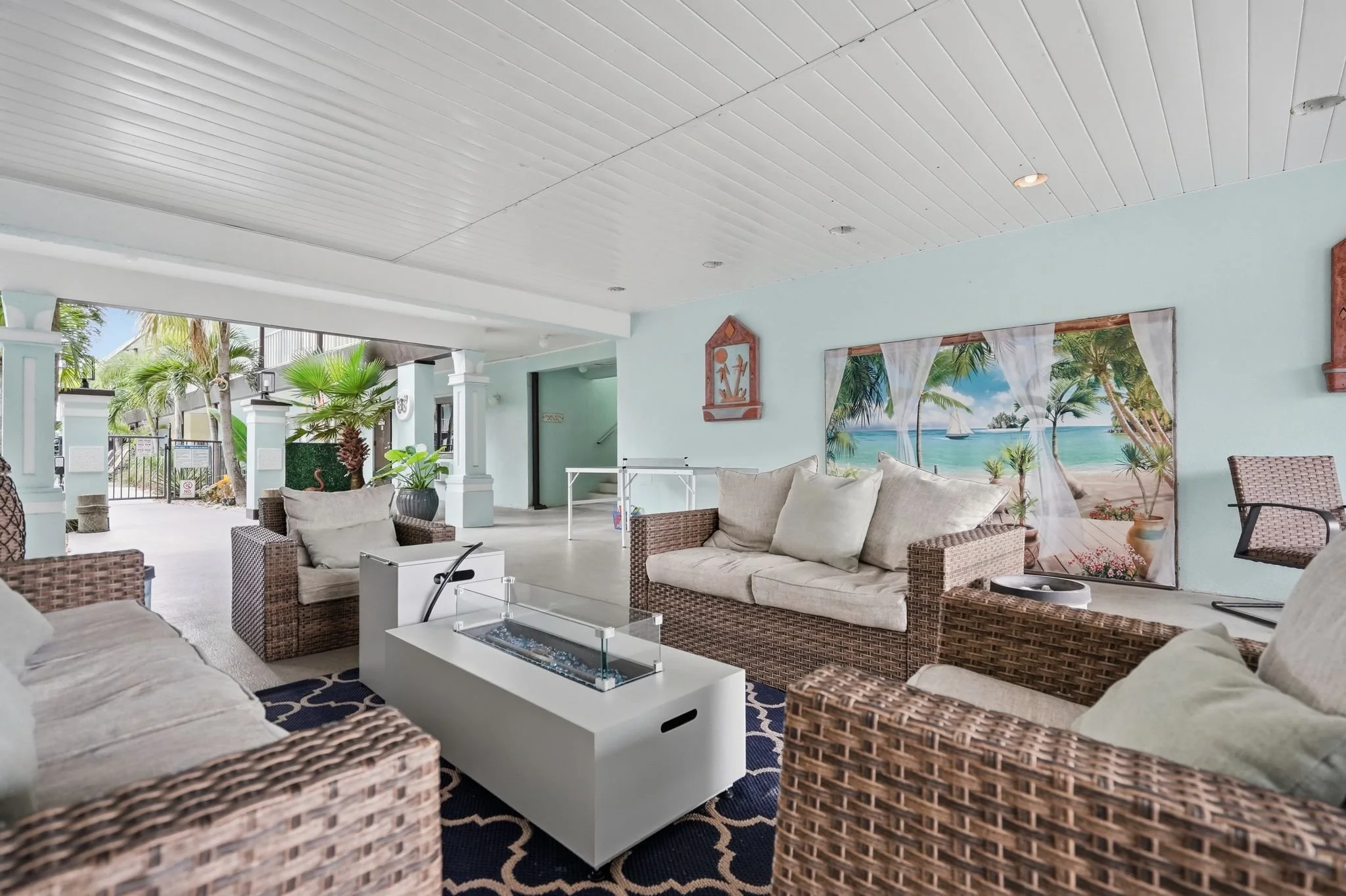 Open-air lobby lounge with wicker seating and gas fire table at Island House Resort Hotel