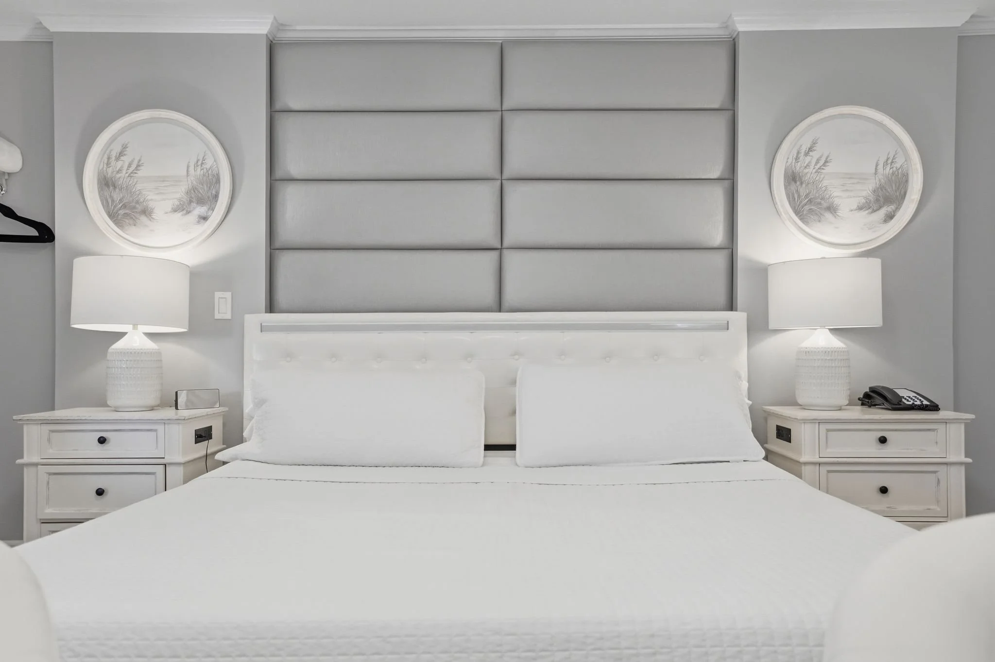 King bed with upholstered headboard and shell and starfish artwork in a Standard King room