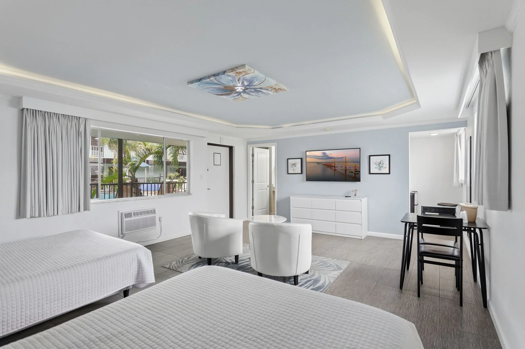 Standard Plus Two Queen room with sitting area and dining table at Island House Resort Hotel