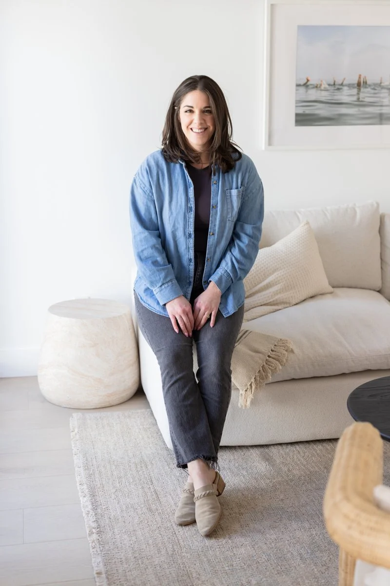 AnnMarie Rose, business strategist, sitting on a cream-colored sofa smiling