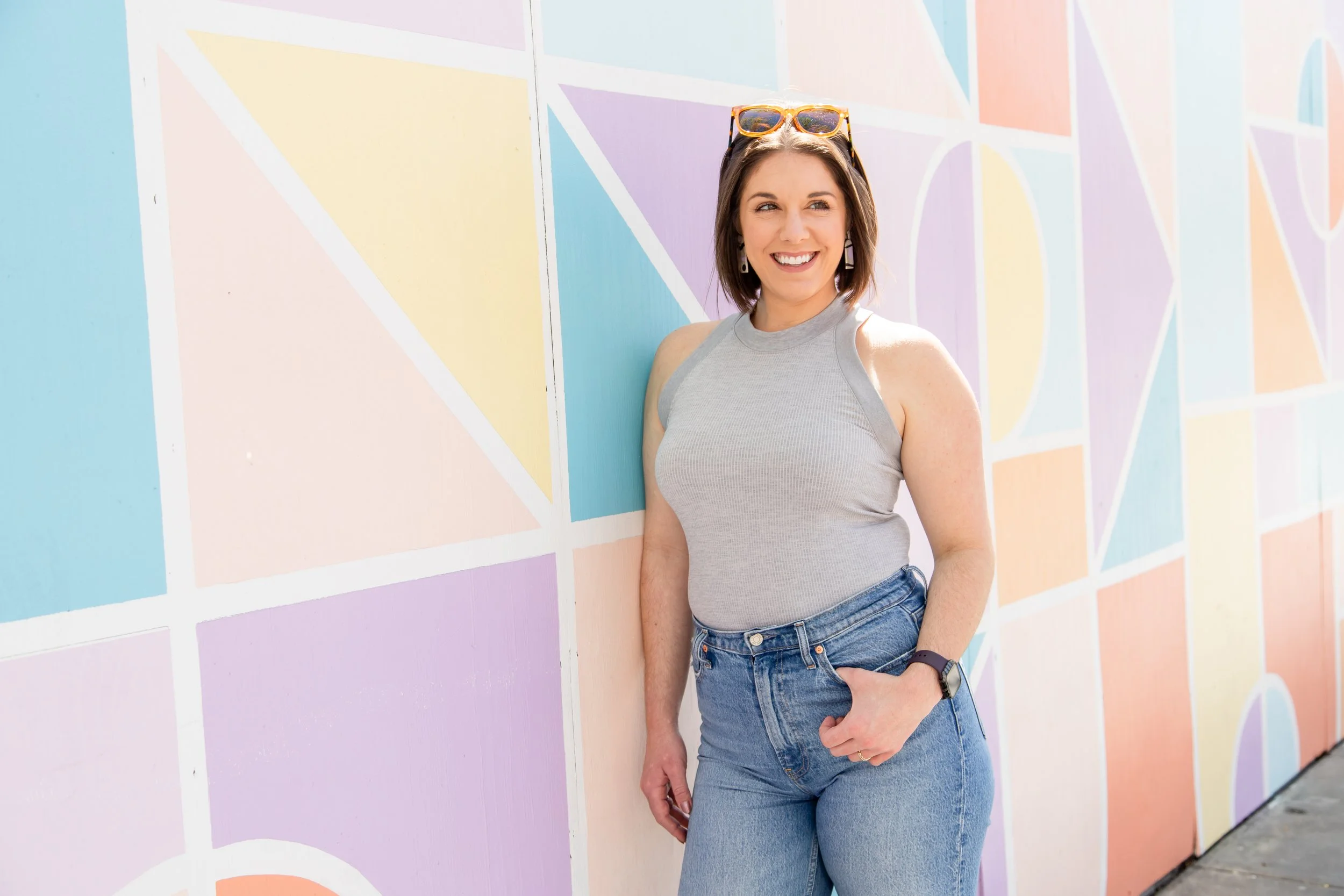 AnnMarie Rose business strategist standing and smiling against a colorful wall