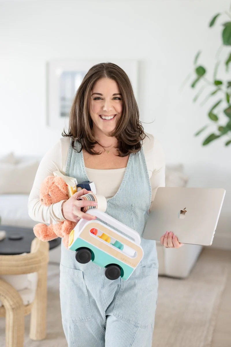 AnnMarie Rose holding children toys and a macbook