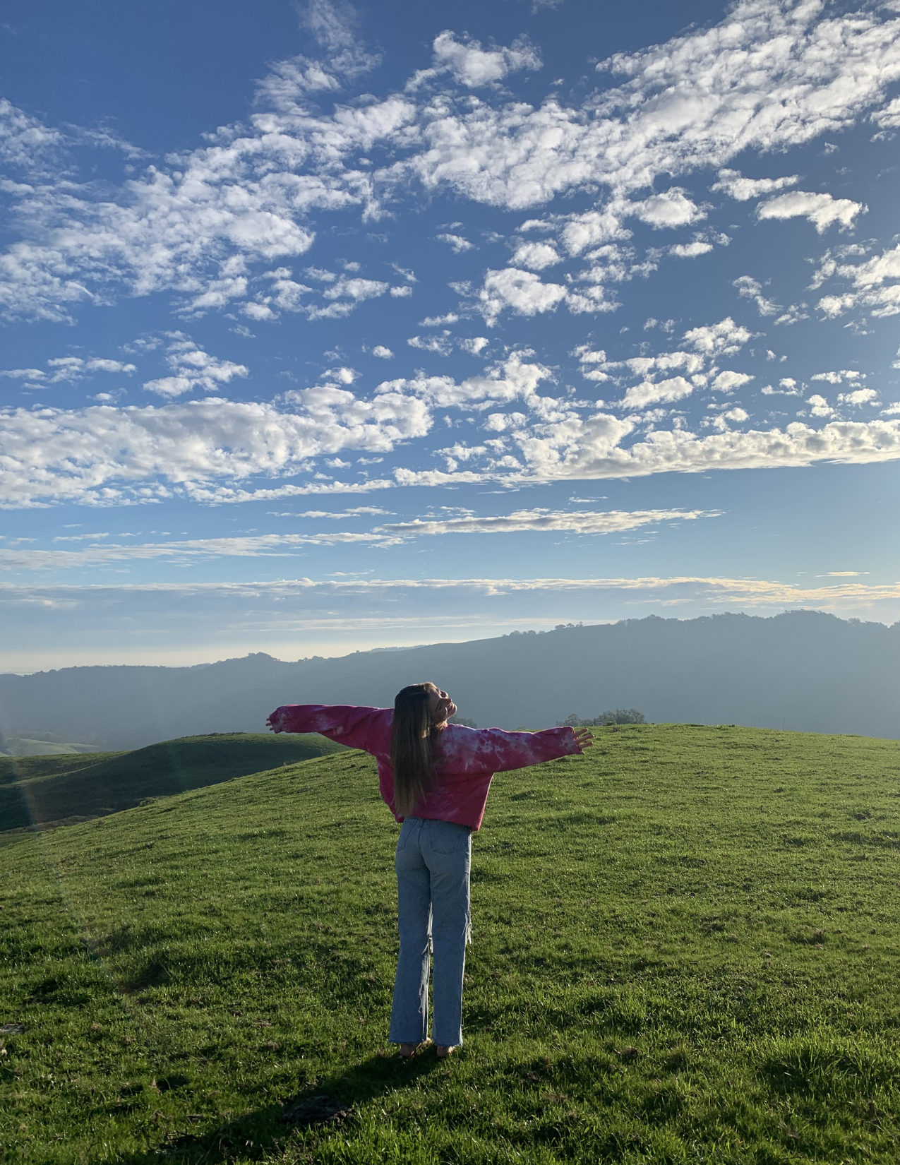A woman embracing the breathtaking views of Napa Valley from a hilltop — capturing the freedom and beauty of wine country that inspired the story of Safe Drive Napa.
