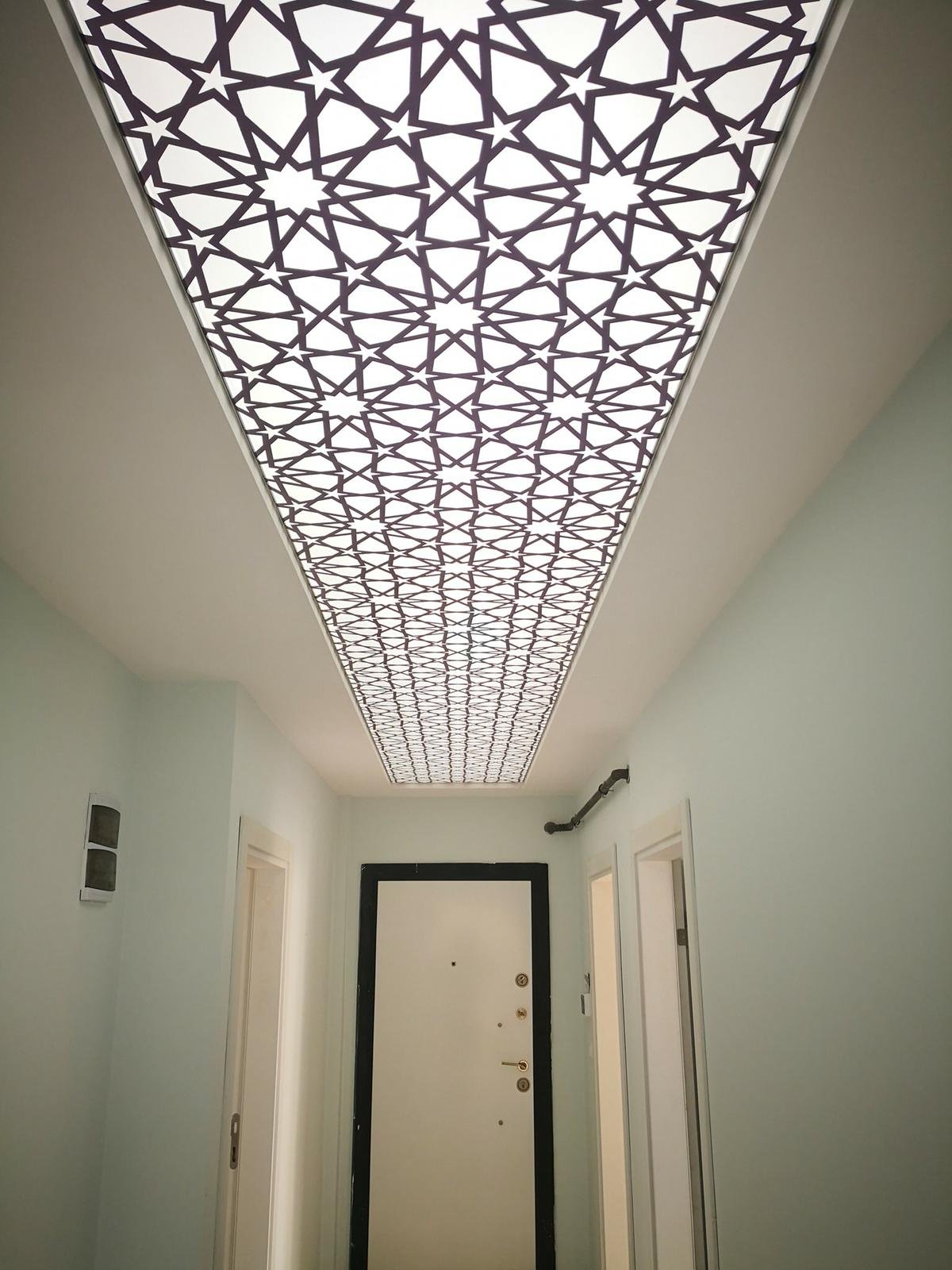 Tavan dekorasyonu olarak kullanılan, geleneksel geometrik desenlere sahip, lamba veya aydınlatma paneli.