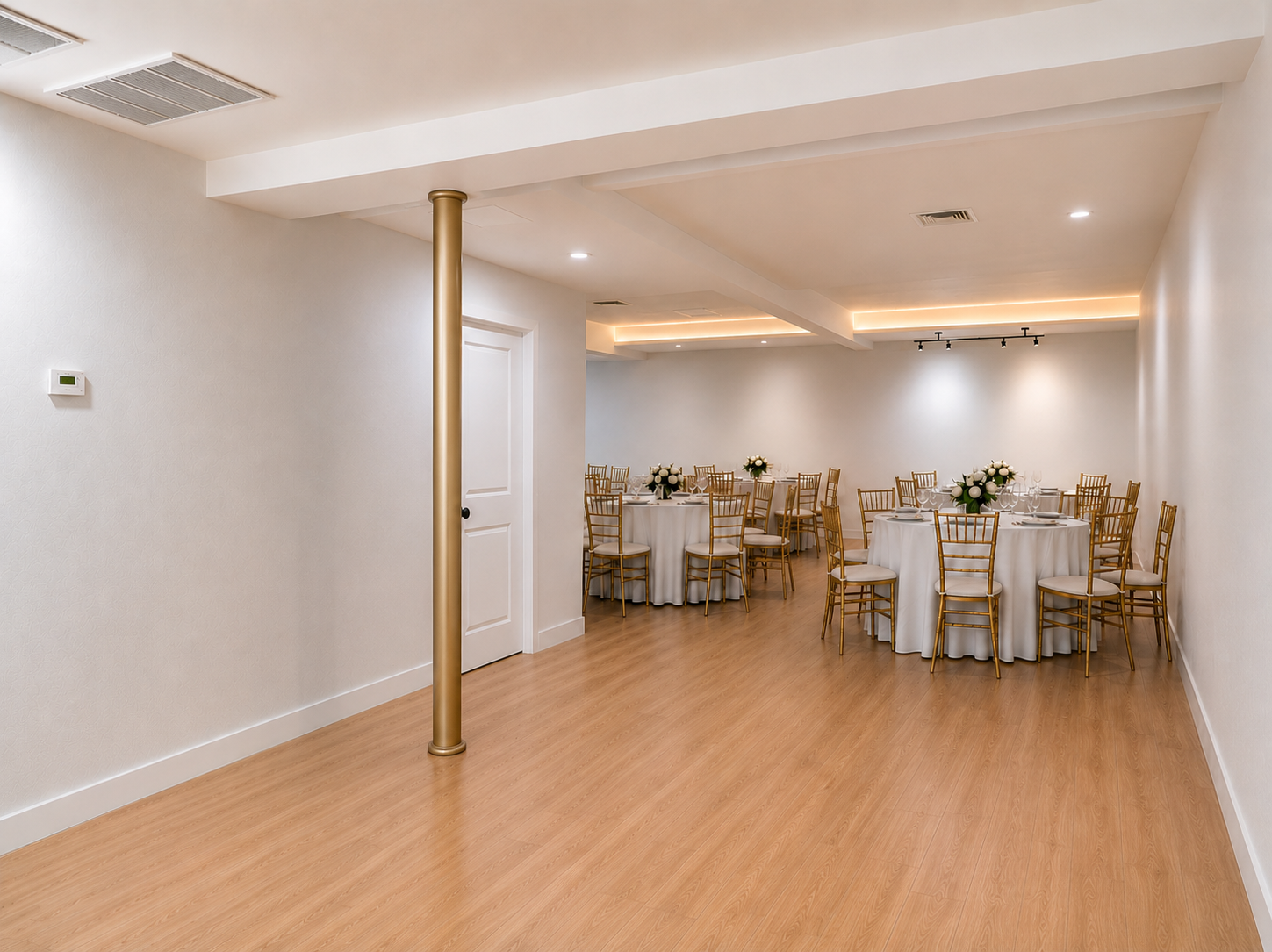 Empty banquet hall with round tables, white tablecloths, gold chairs, floral centerpieces, and soft lighting.