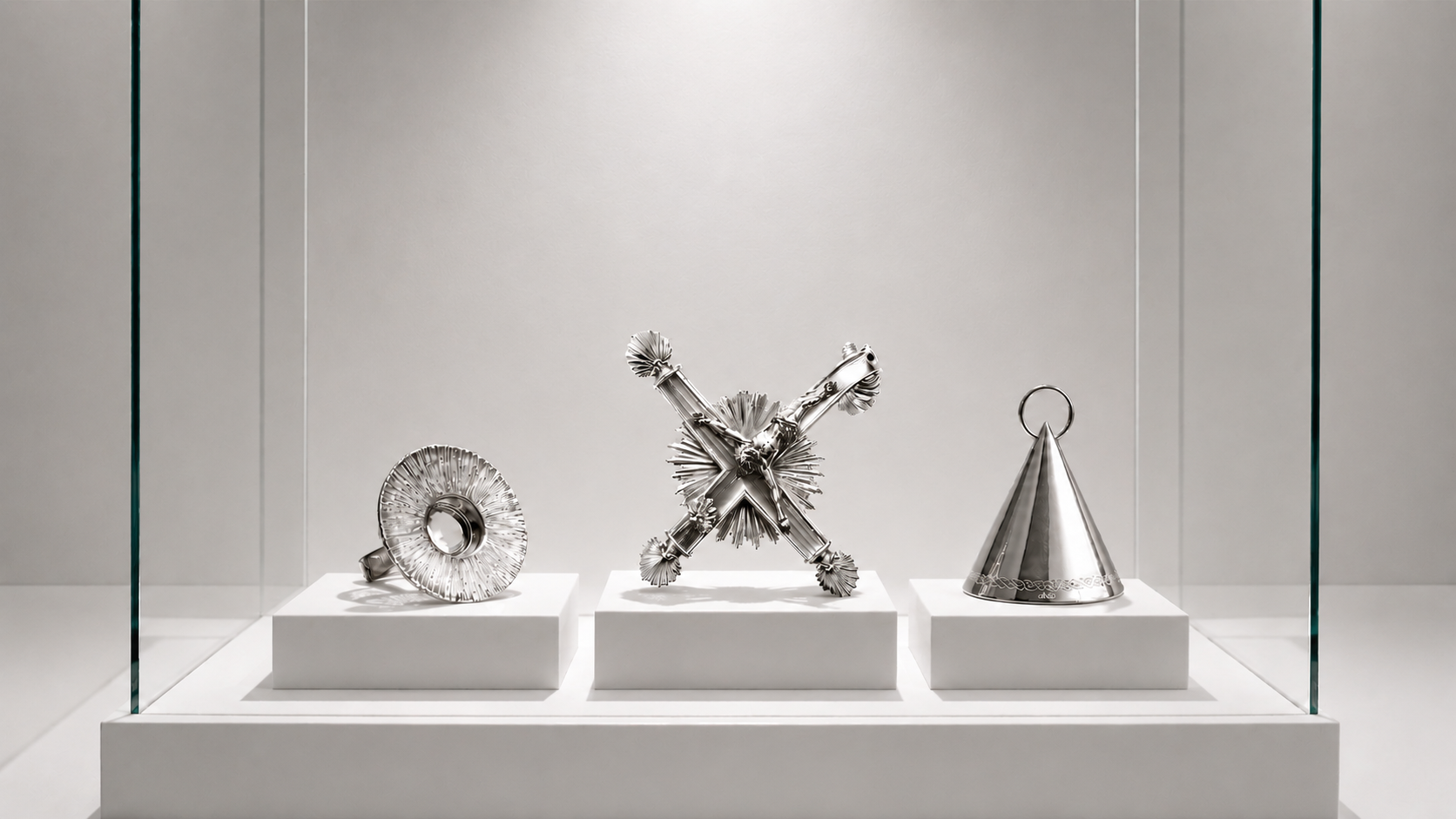 Three contemporary silver jewelry pieces from Objects of Devotion by Fer Quirarte, including a pendant inspired by the bent Christ of the Basilica of Our Lady of Guadalupe, exploring faith, memory, and devotion.