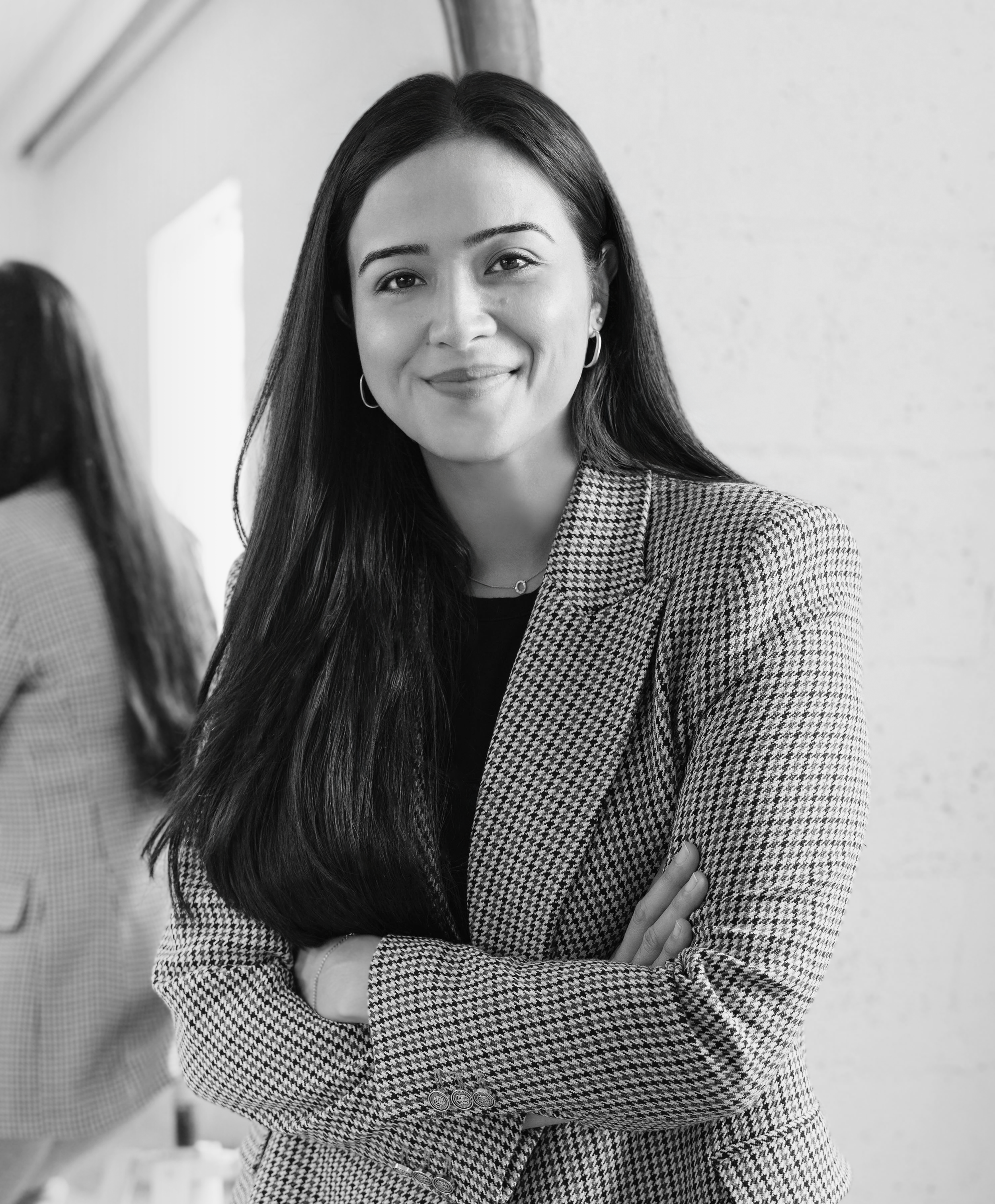Renata Ray Bastos, founder of Trace Design Studio, smiling in a houndstooth blazer — Miami and New York interior designer.