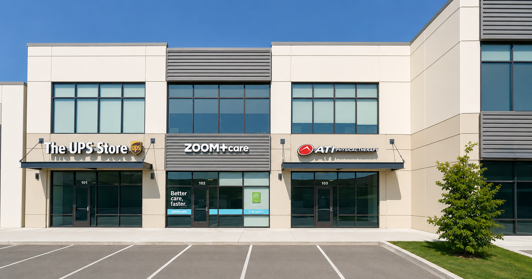 Modern commercial building with three storefronts: The UPS Store, ZOOM+Care, and ATI Physical Therapy, with parking lot and small tree in front.