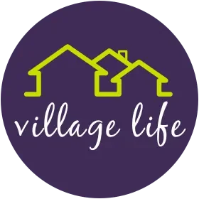 Logo with three yellow house outlines and the words 'village life' in white cursive on a purple circular background.