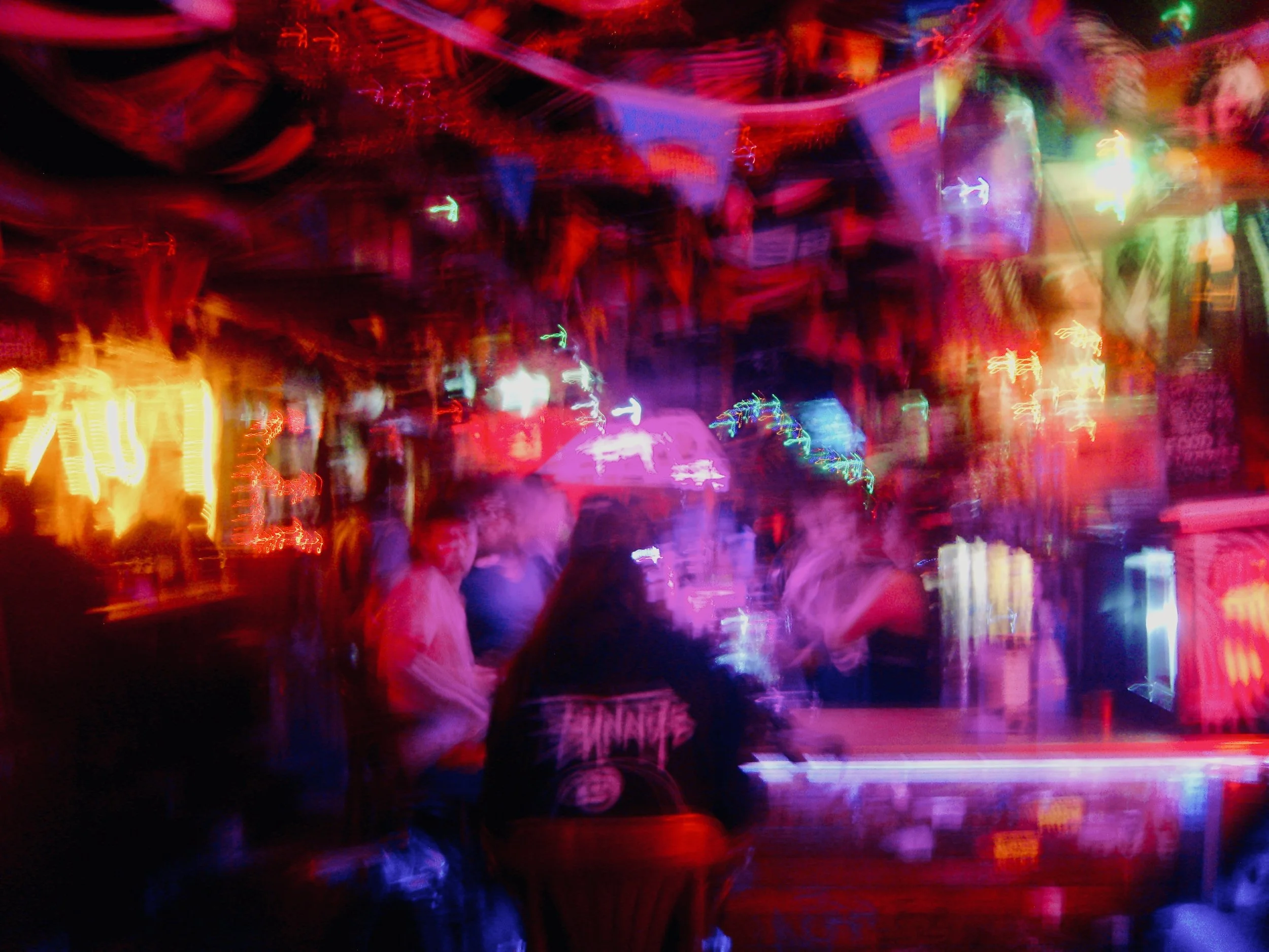 Brightly colored lights creating a blurry, abstract scene likely at a nightclub or entertainment venue.