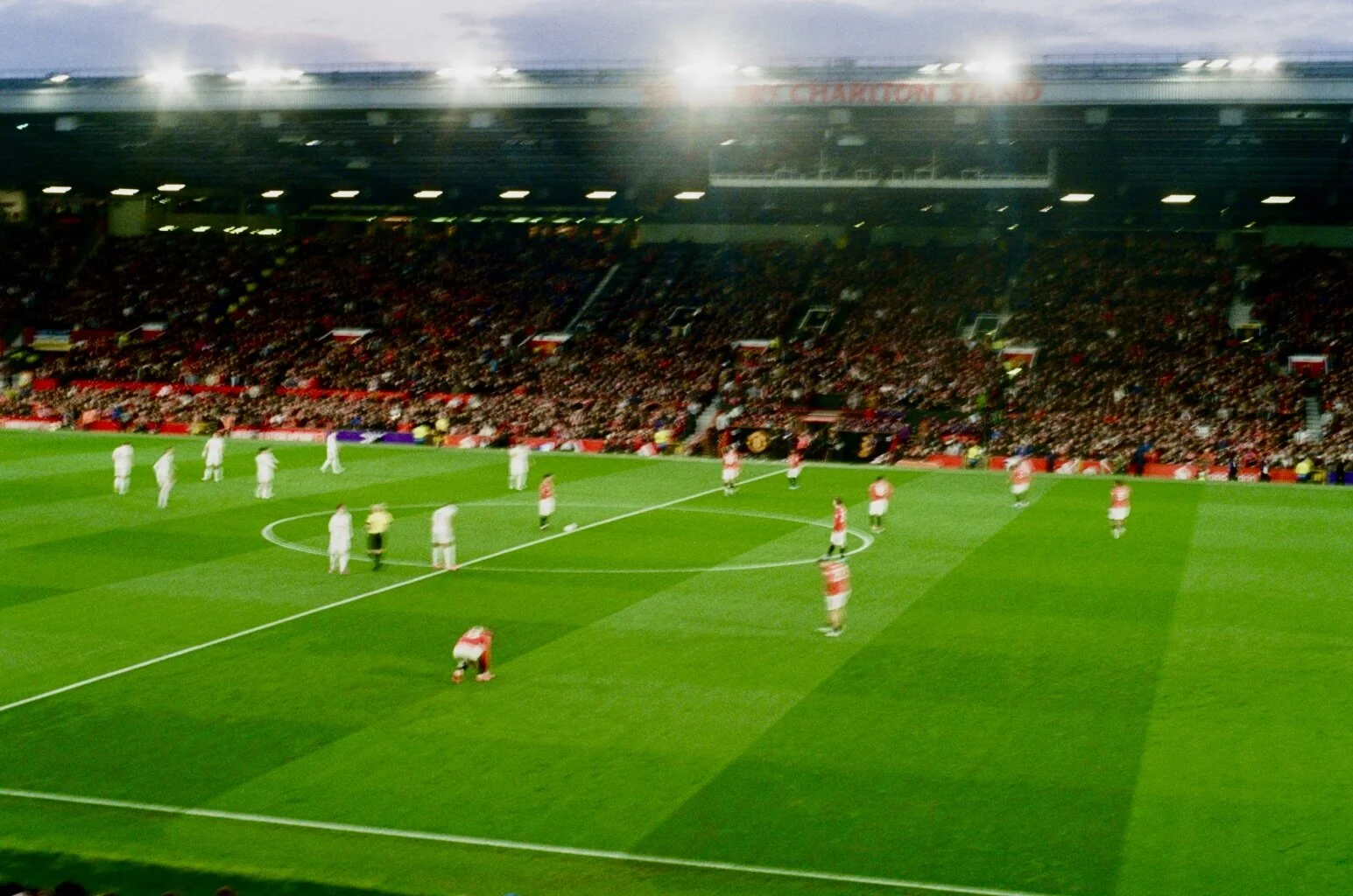 Soccer match at a stadium with players on the field and a large crowd in the stands.