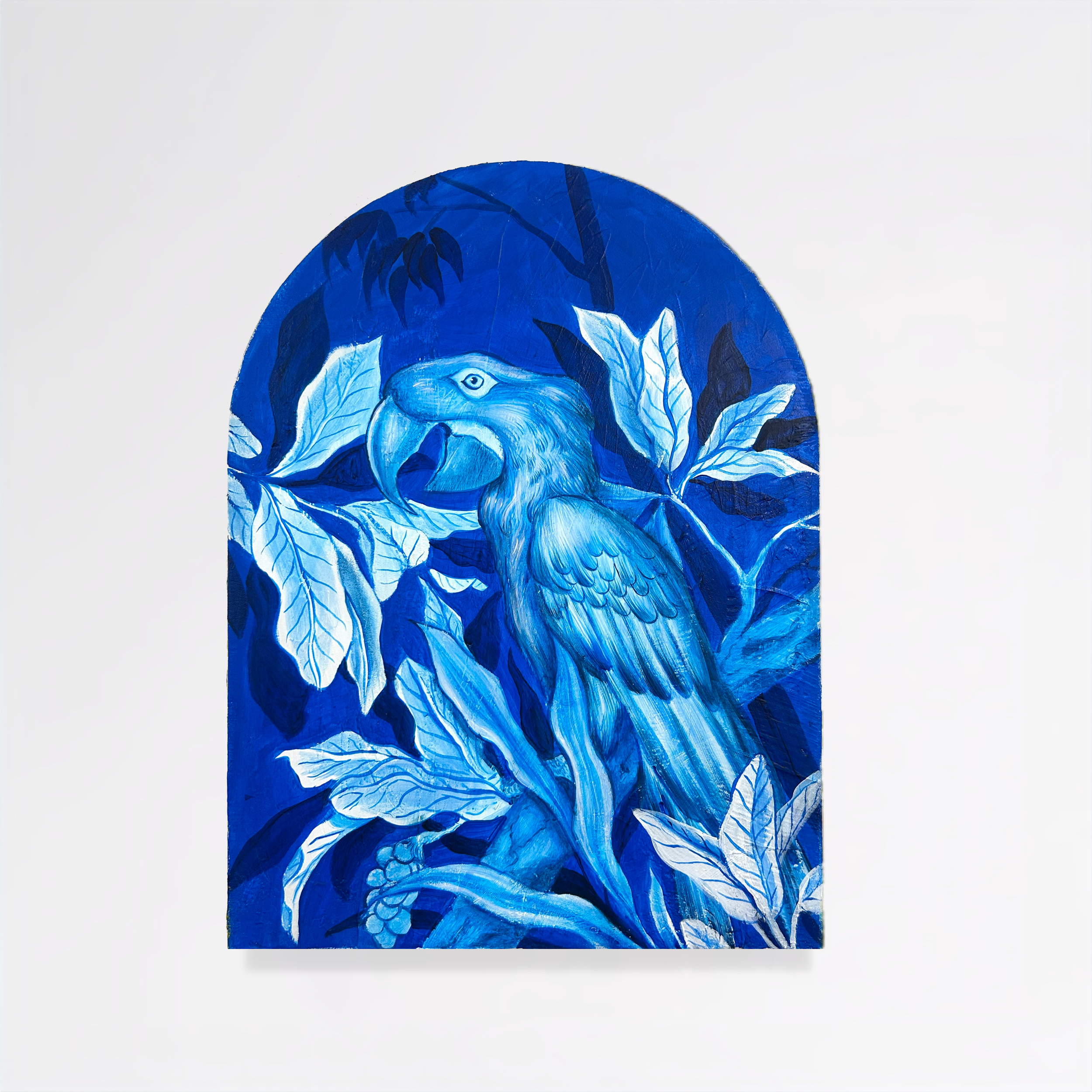 Artwork featuring a blue-toned illustration of a bird, possibly a parrot, surrounded by large leaves.