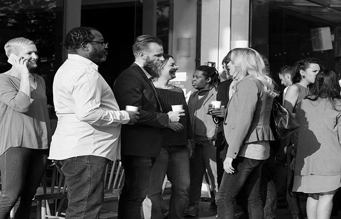 Business professionals networking at a corporate event, representing public relations, media relations, strategic communications, brand reputation management, and community engagement.