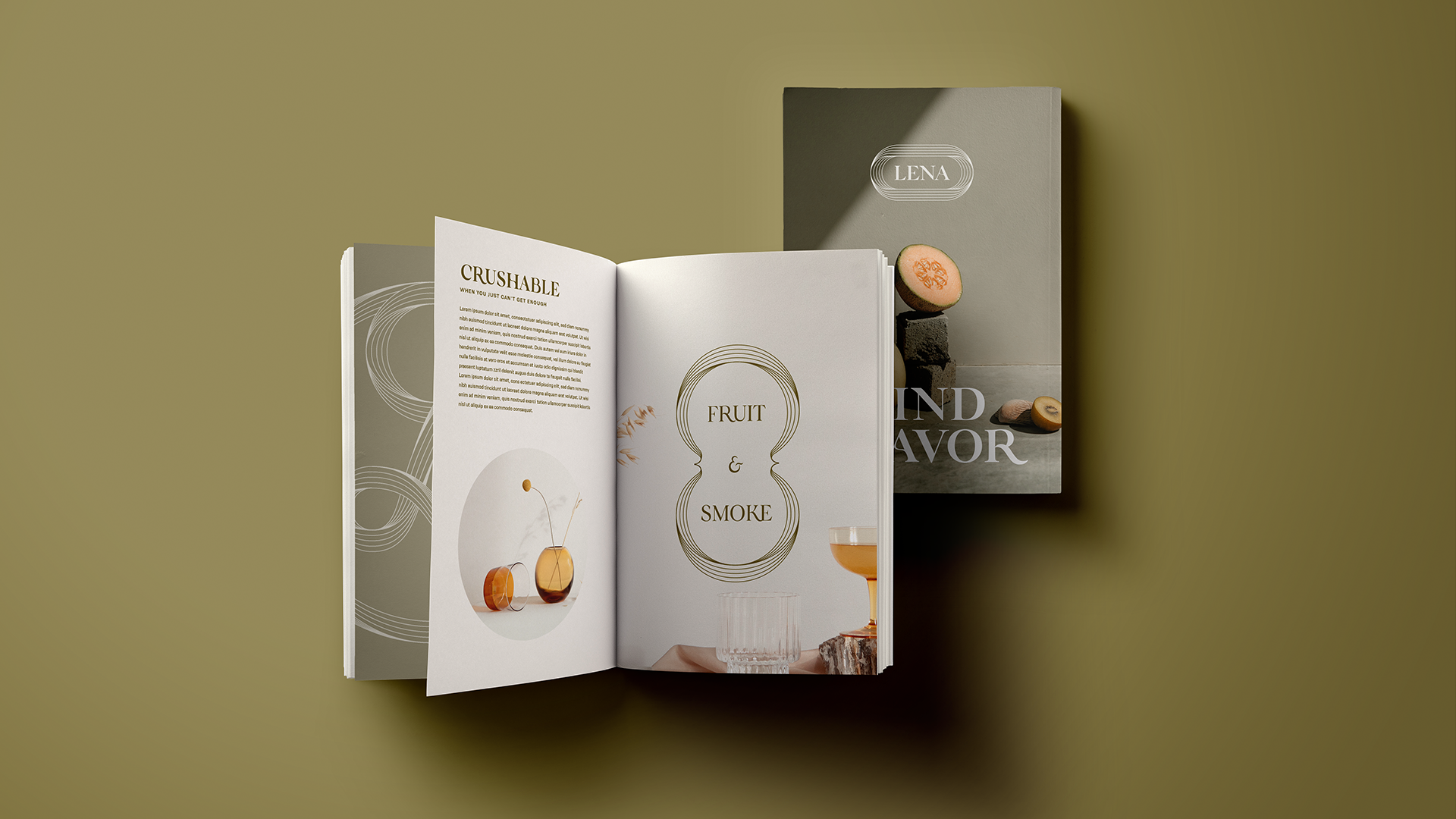 Open magazine showing pages titled "Crushable" and "Fruit & Smoke" alongside a folded brochure titled "LENA" with a food display featuring sliced fruit on a gray background.