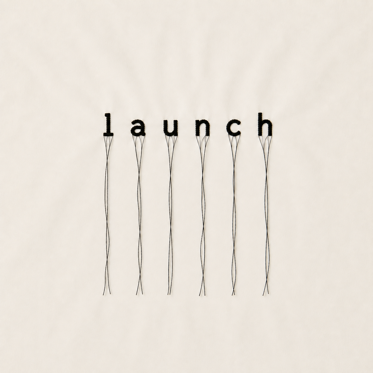 Wall art spelling the word 'lanch' with black letter cutouts, each attached to thin, winding wires.