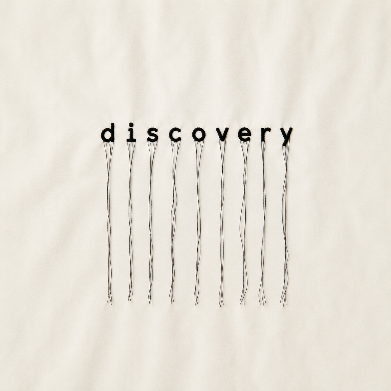 The word 'discovery' spelled with black letters, each attached to thin wires extending downward.