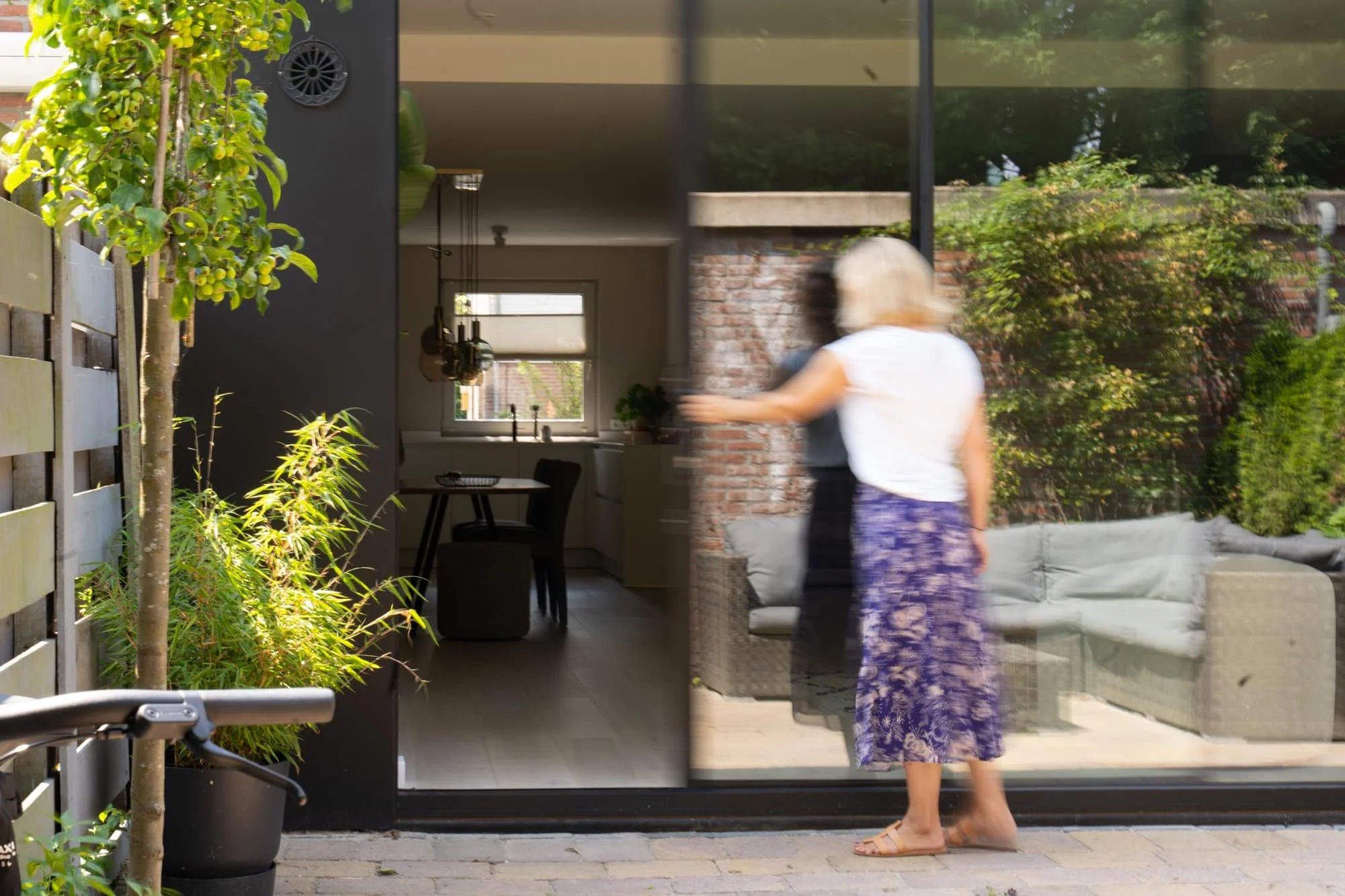 Open rear extension with garden view, black framed glazing and warm interior atmosphere