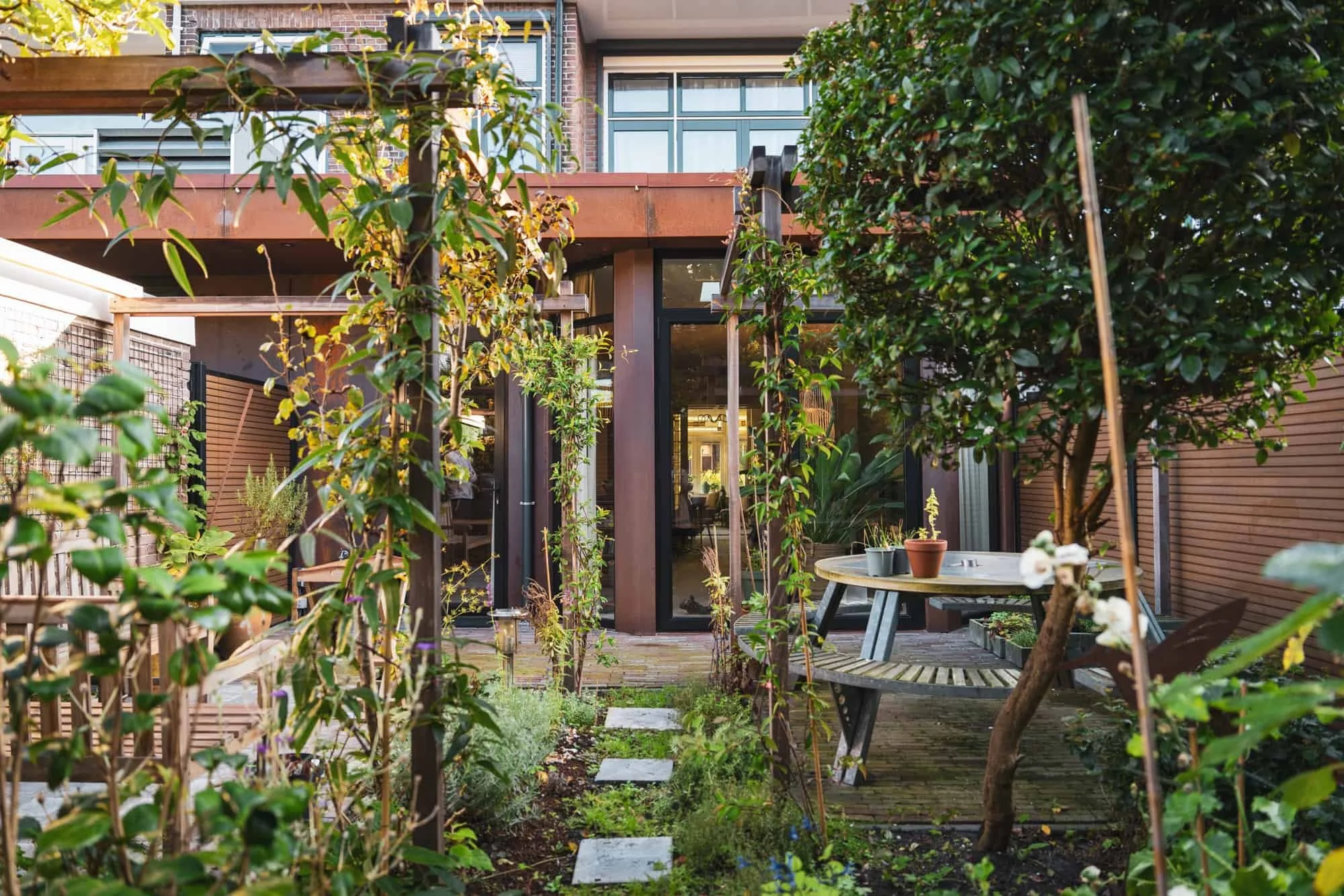 Garden view of corten steel extension with lush greenery, Vondellaan, Rijswijk