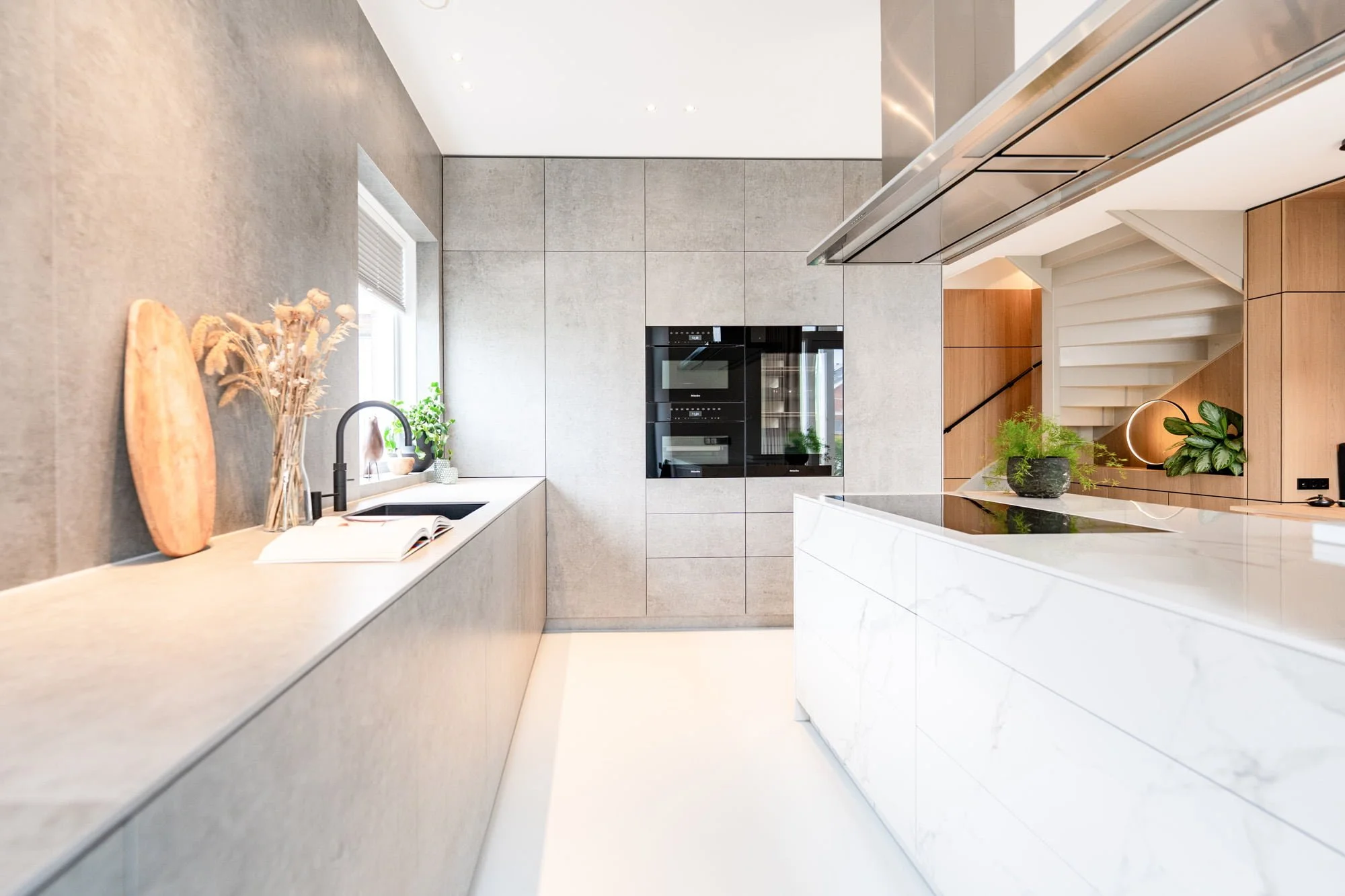 Bright open kitchen with white natural stone island, light oak cabinetry and soft daylight