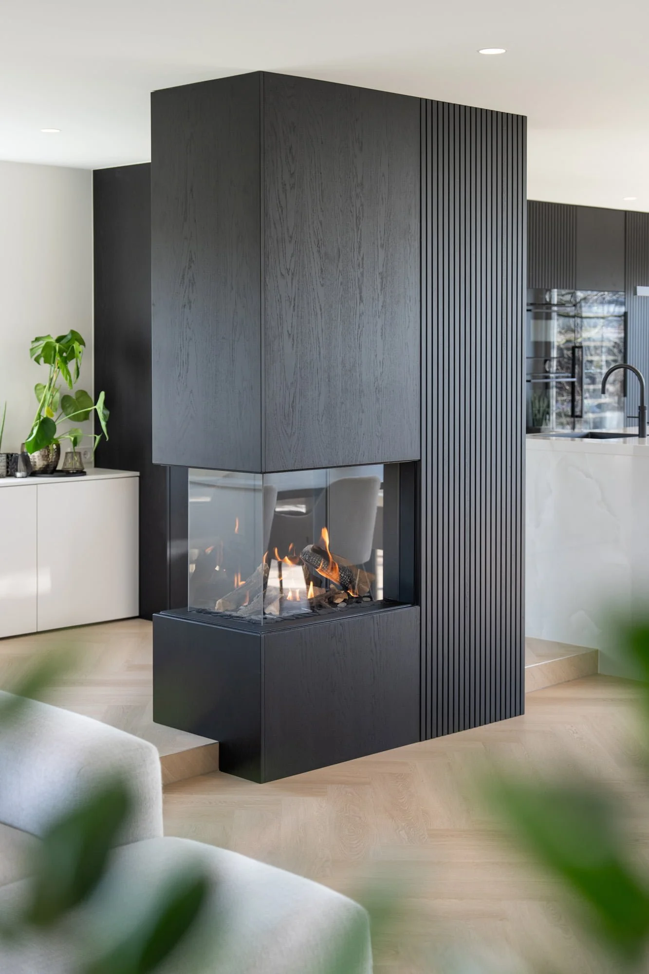 Close up of dark textured fireplace wall with integrated storage and refined detailing
