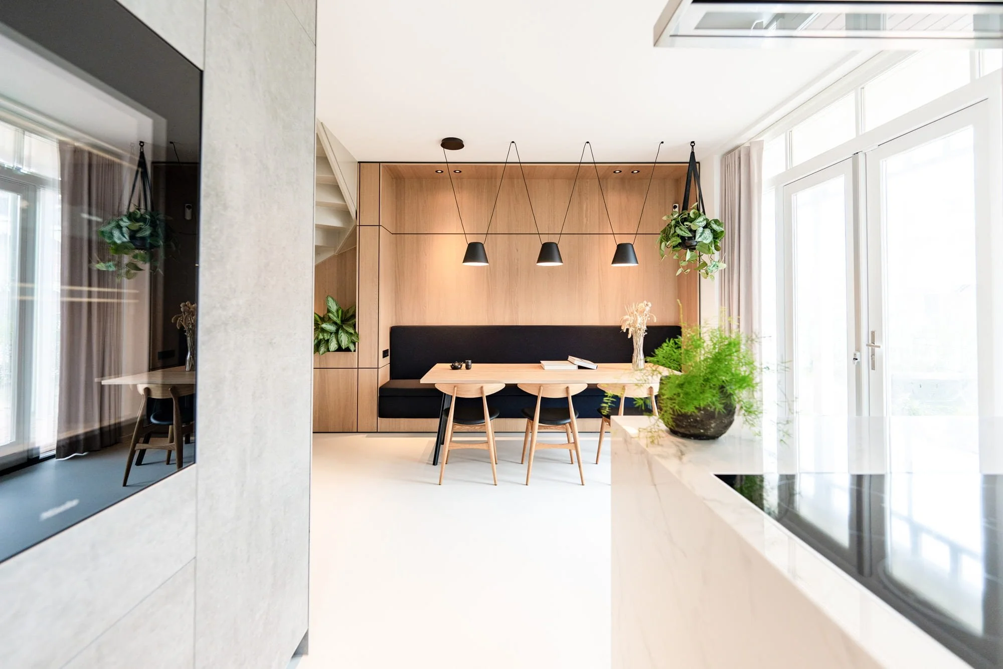 Minimal kitchen and dining space with natural materials, garden view and soft neutral tones