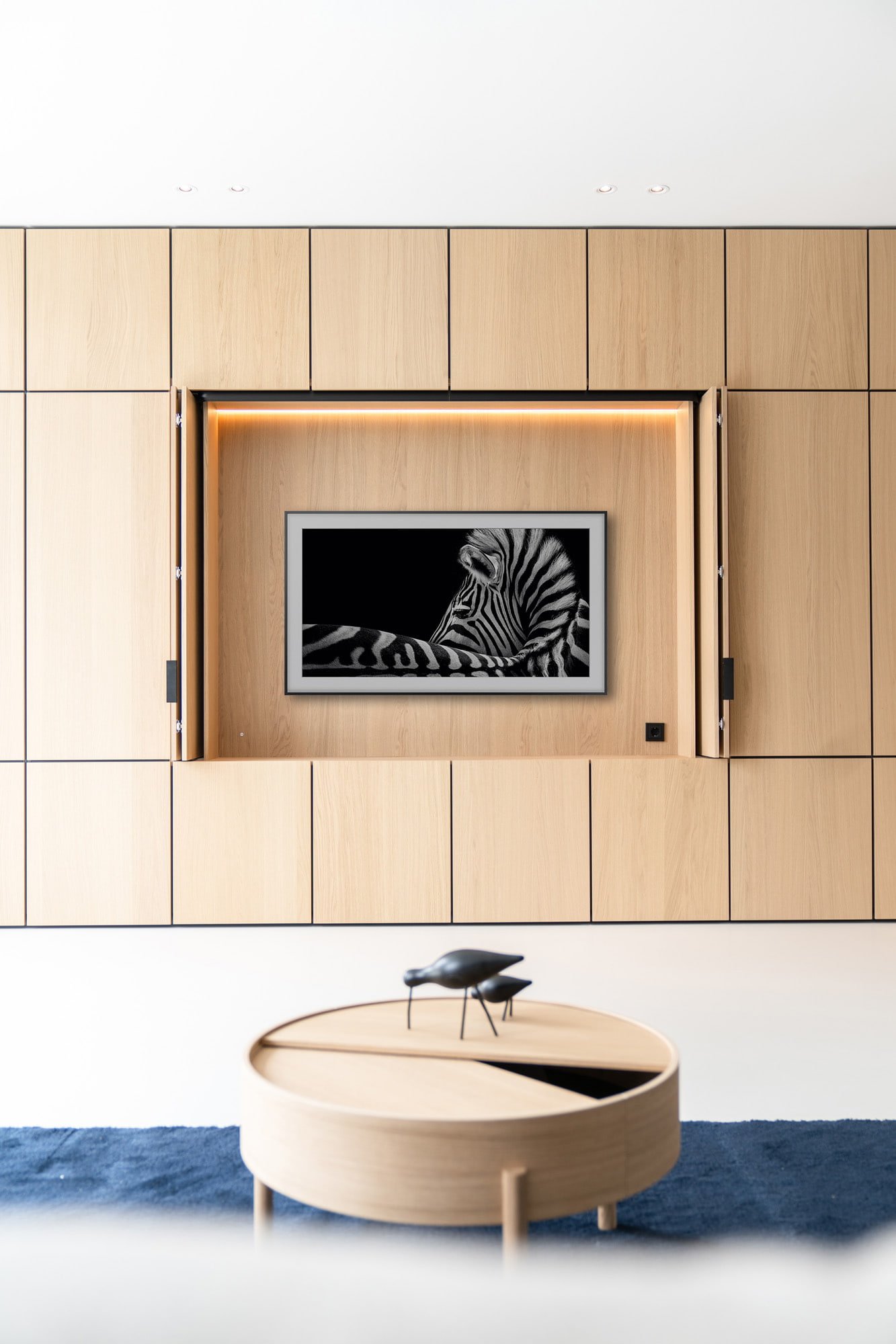 Detail of oak wall panelling with integrated artwork and refined interior styling