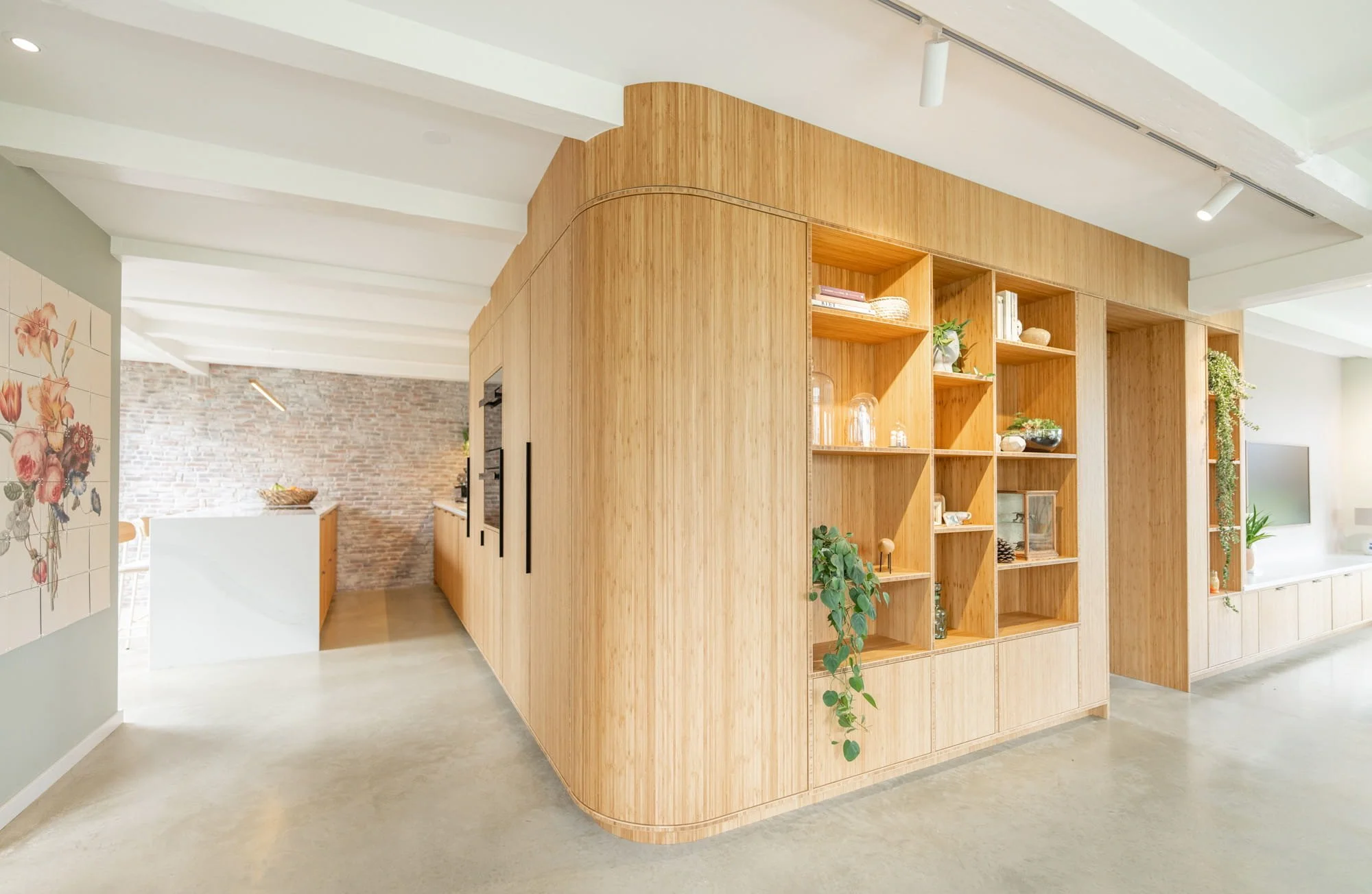 Curved oak room divider with open shelving in a refined residential interior