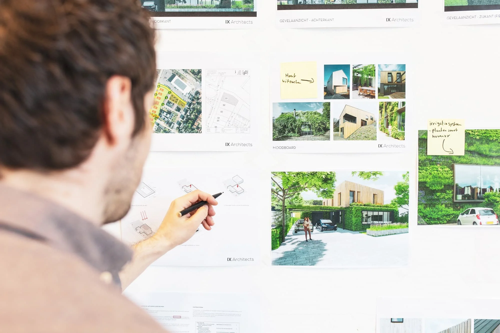 Architect reviewing exterior design presentation with landscape and facade references
