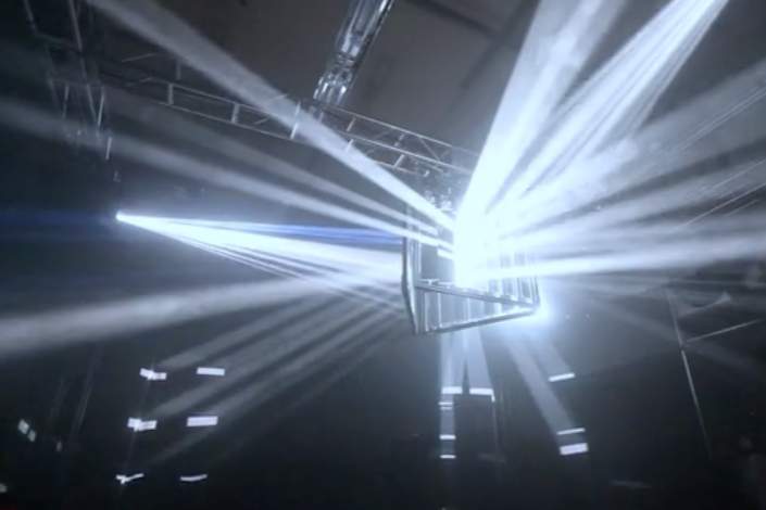 Robotic mirrors steer projected light shining through fog or haze in a dark room.