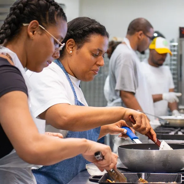 Volunteers cooking in kitchen