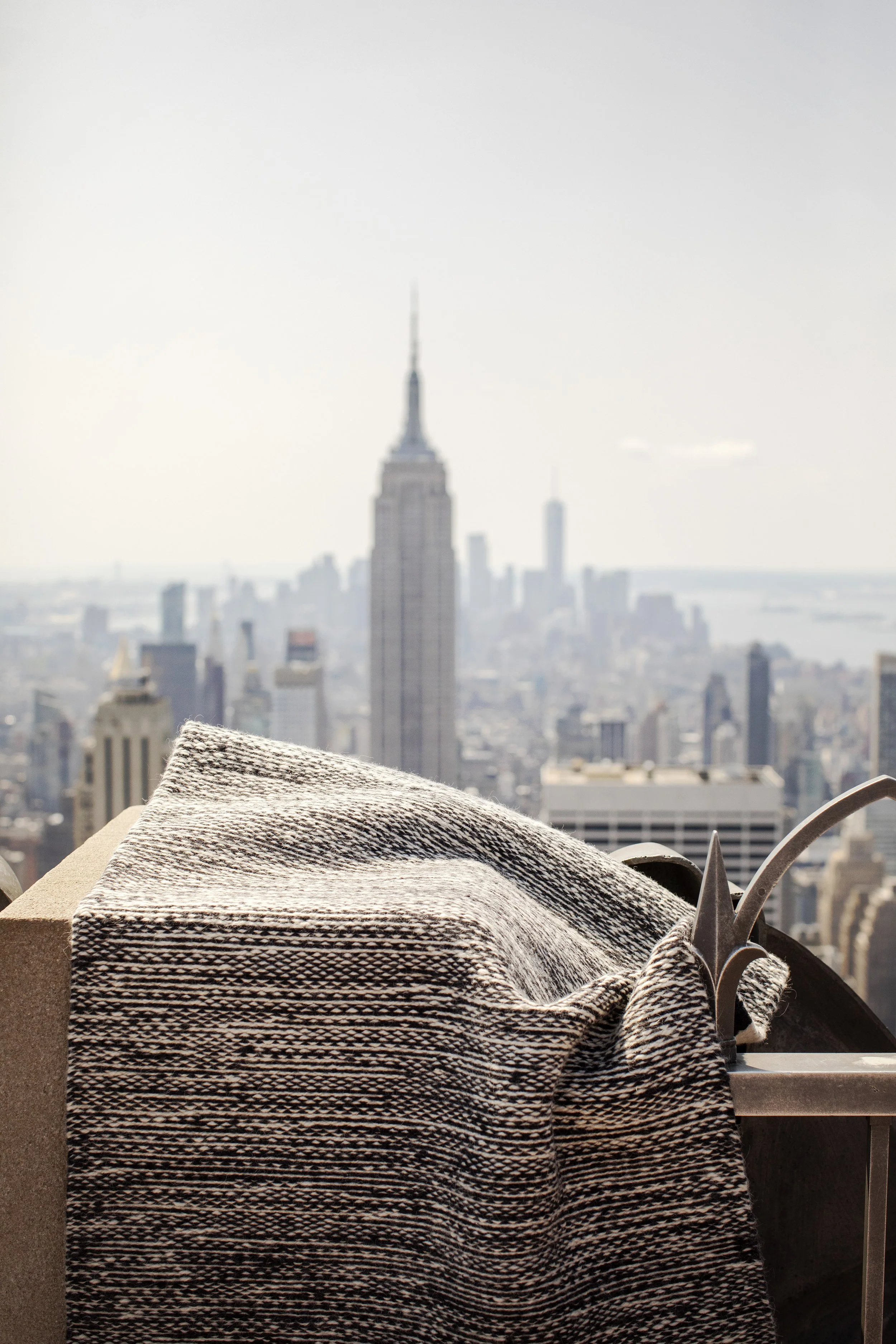 Black-and-white patterned sofa overlooking the New York City skyline and Empire State Building