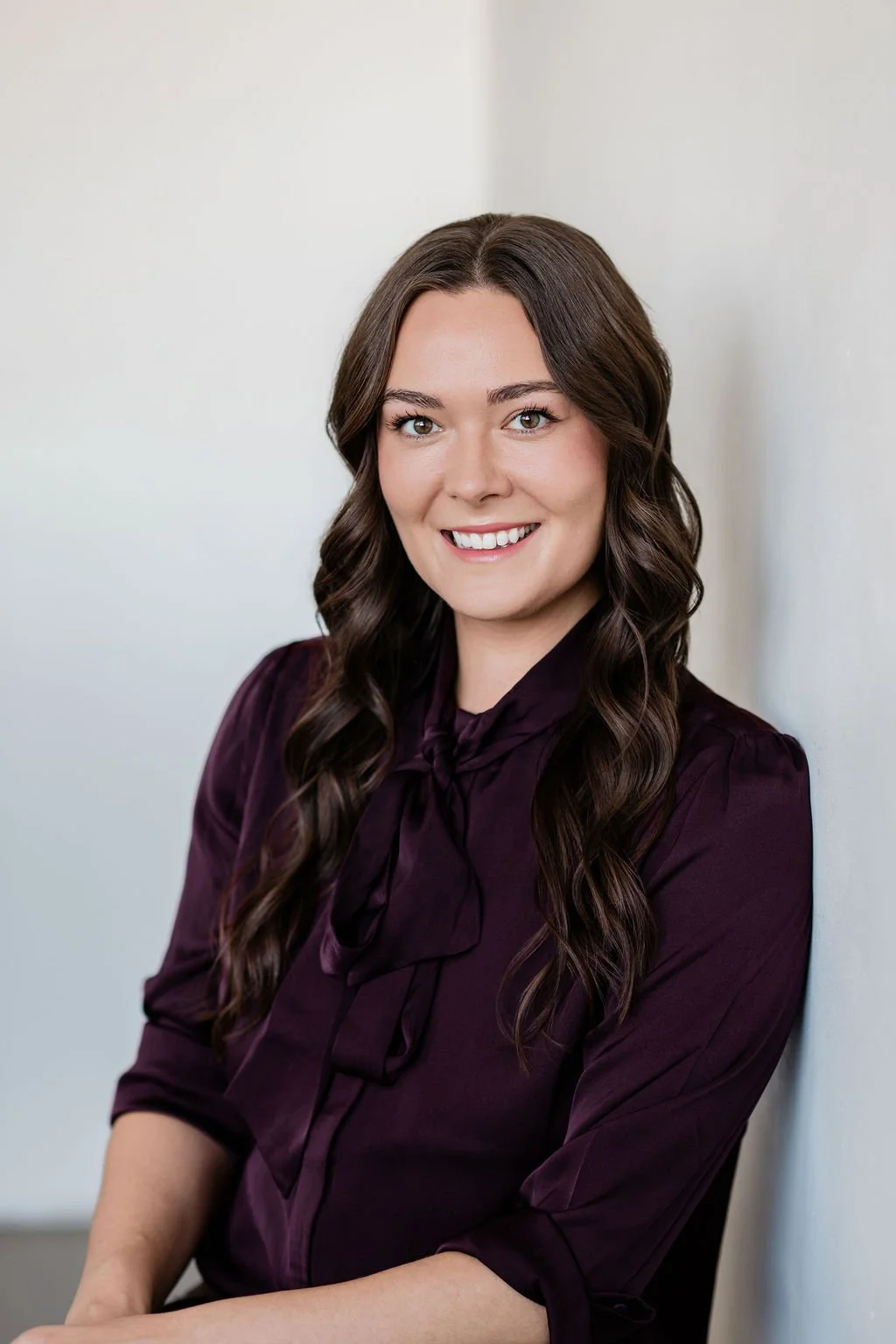 Portrait of Dr. Erin Hendrix, psychiatrist and founder of Origins Psychiatry in Grand Rapids, Michigan, smiling in a burgundy blouse.