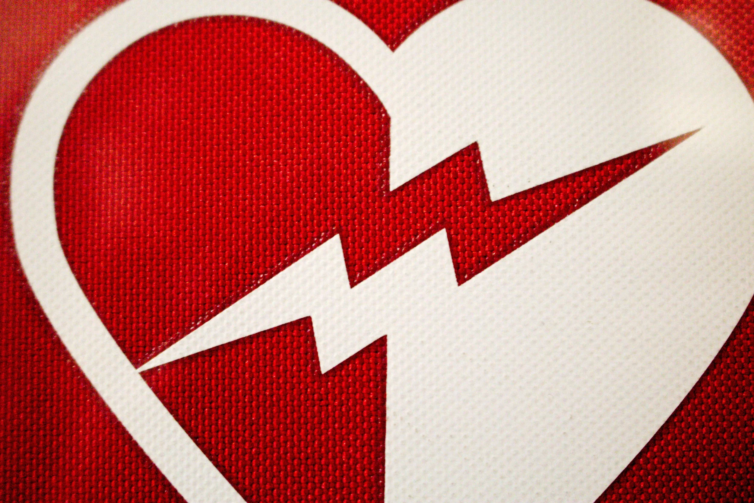 Close-up of a fabric with a red heart and a white lightning bolt symbol inside a circle.