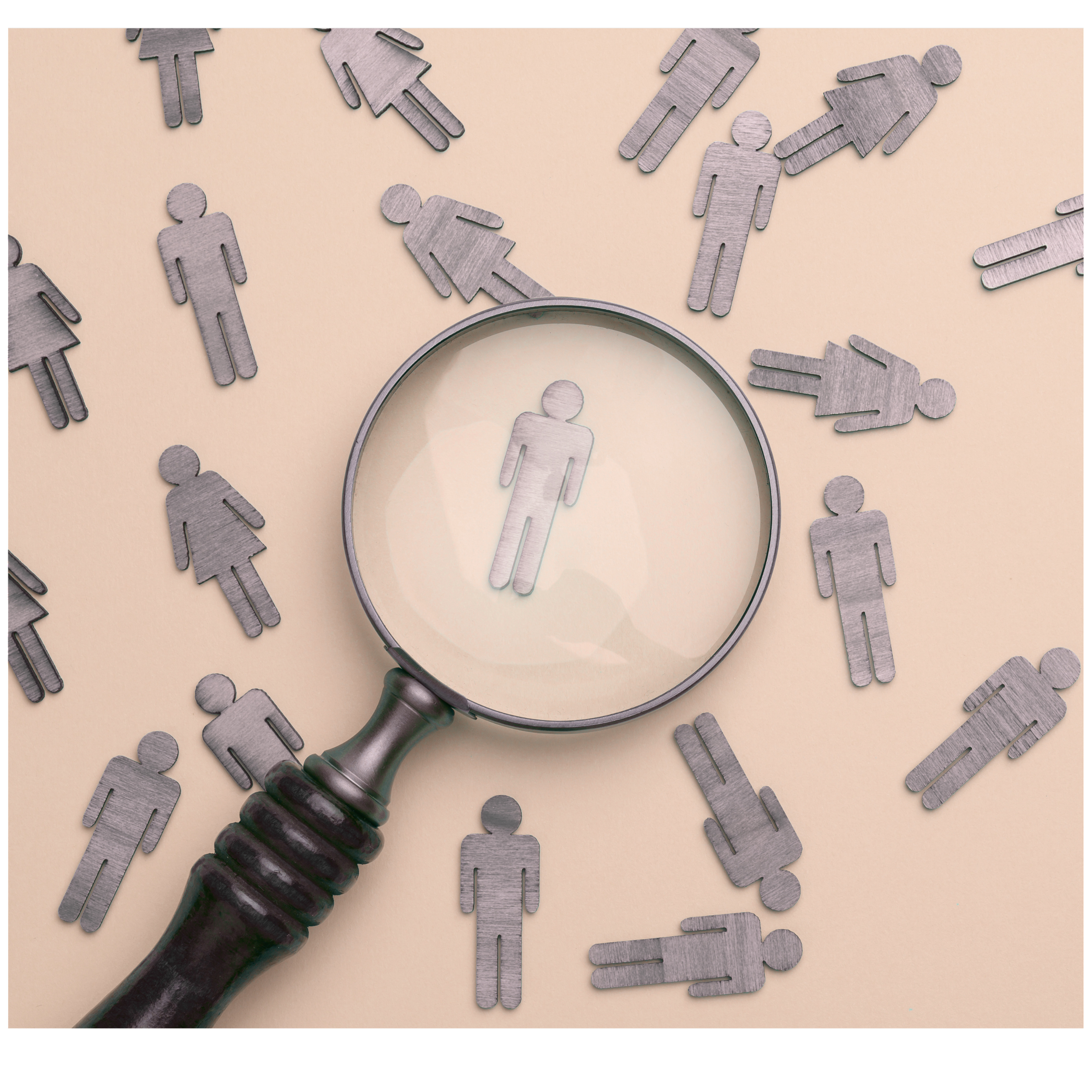 Metal figures of people scattered on a surface with a magnifying glass focusing on a single figure in the center.