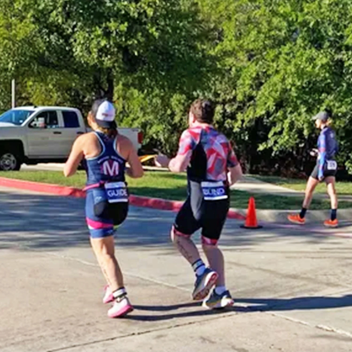 Thomas McCullough running with his sight guide, during a triathlon in 2023.