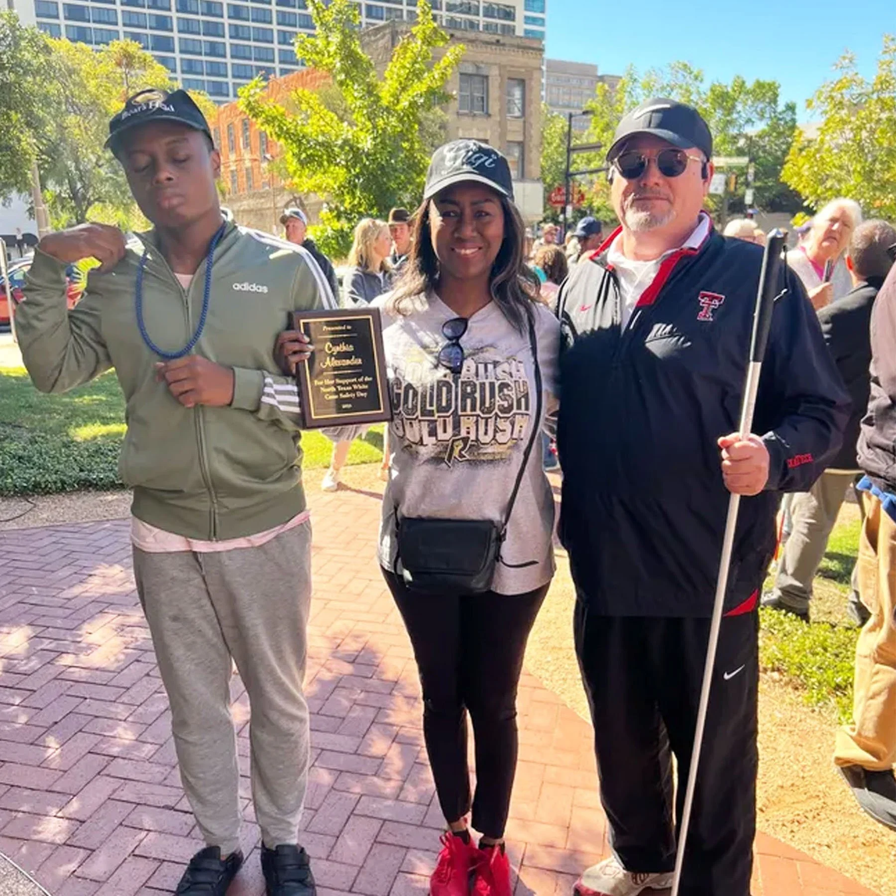 Cynthia Alexander (middle) with her son (left) and Rick SanJuan (right). Cynthia receives an award for Excellence in Leadership and Support on White Cane Day 2023