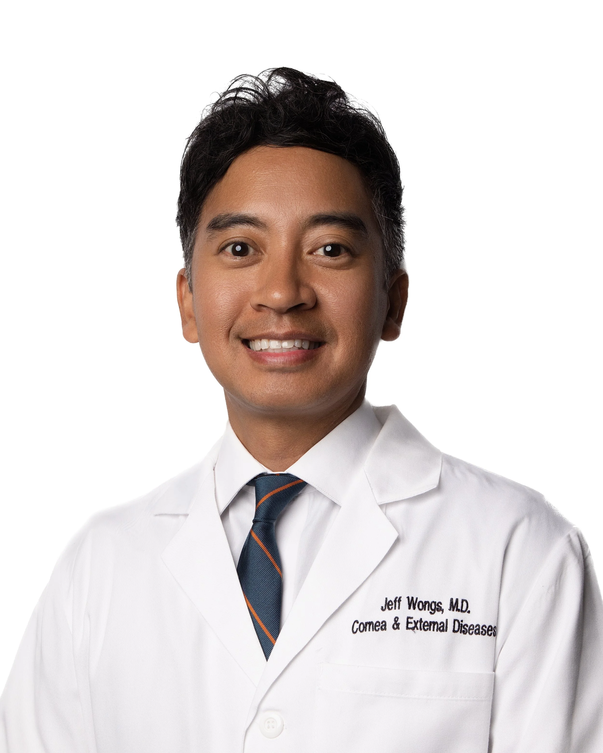 A man in a white medical coat with a tie, smiling, with the name tag reading 'Jeff Wongs, M.D., Comea & External Diseases'.