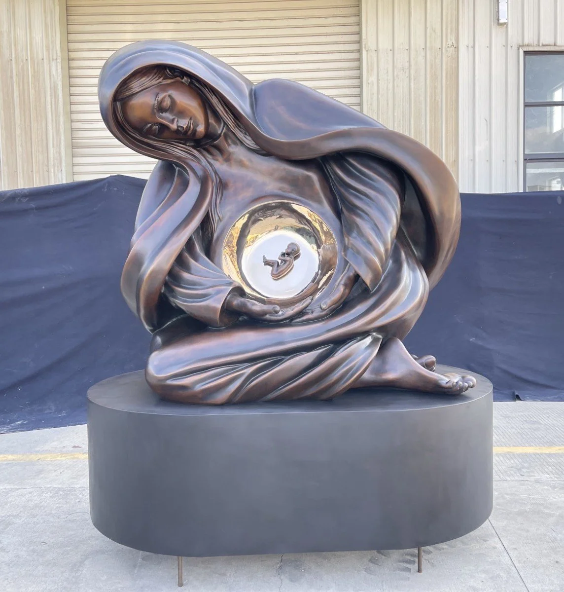 Tim Schmalz's Life Monument sculpture base in black bronze depicting the Virgin Mary with Jesus in the Womb.