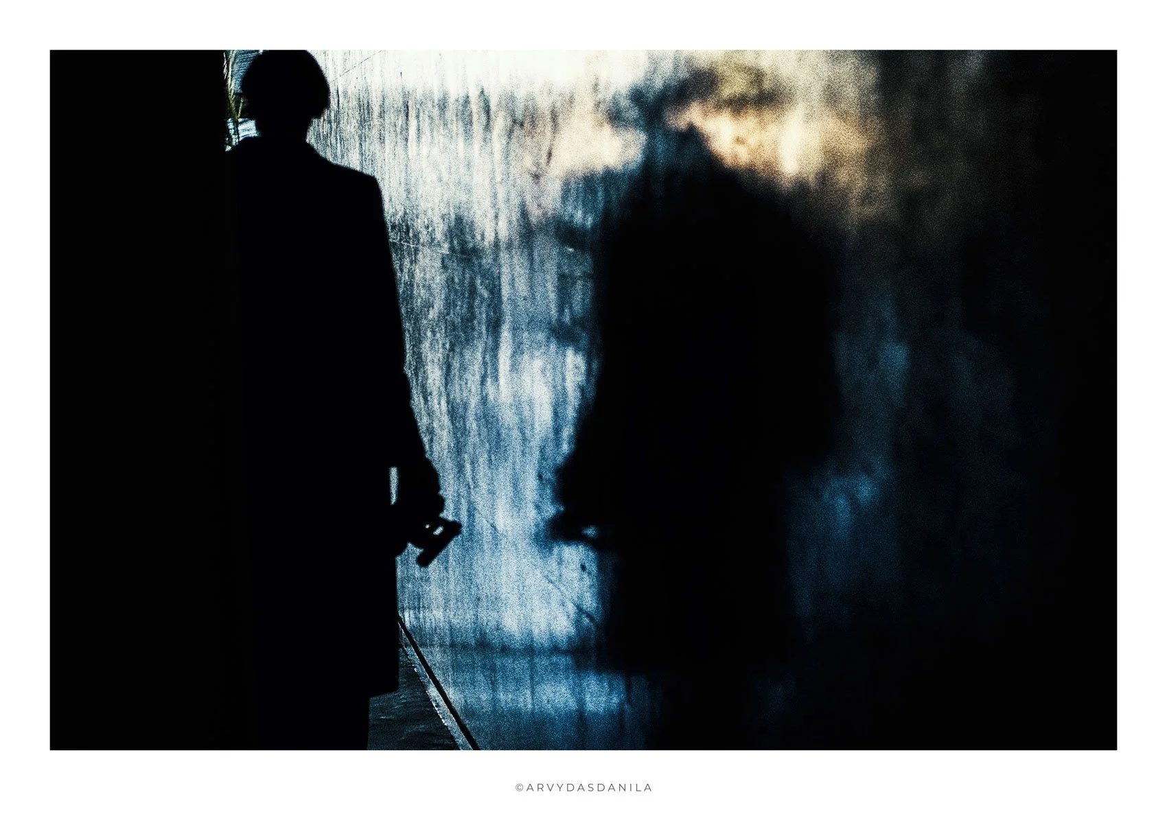 silhouettes shadows and reflections blue theme with a flash of yellow image creates strange sensation of very strong mood radiating from the photograph.