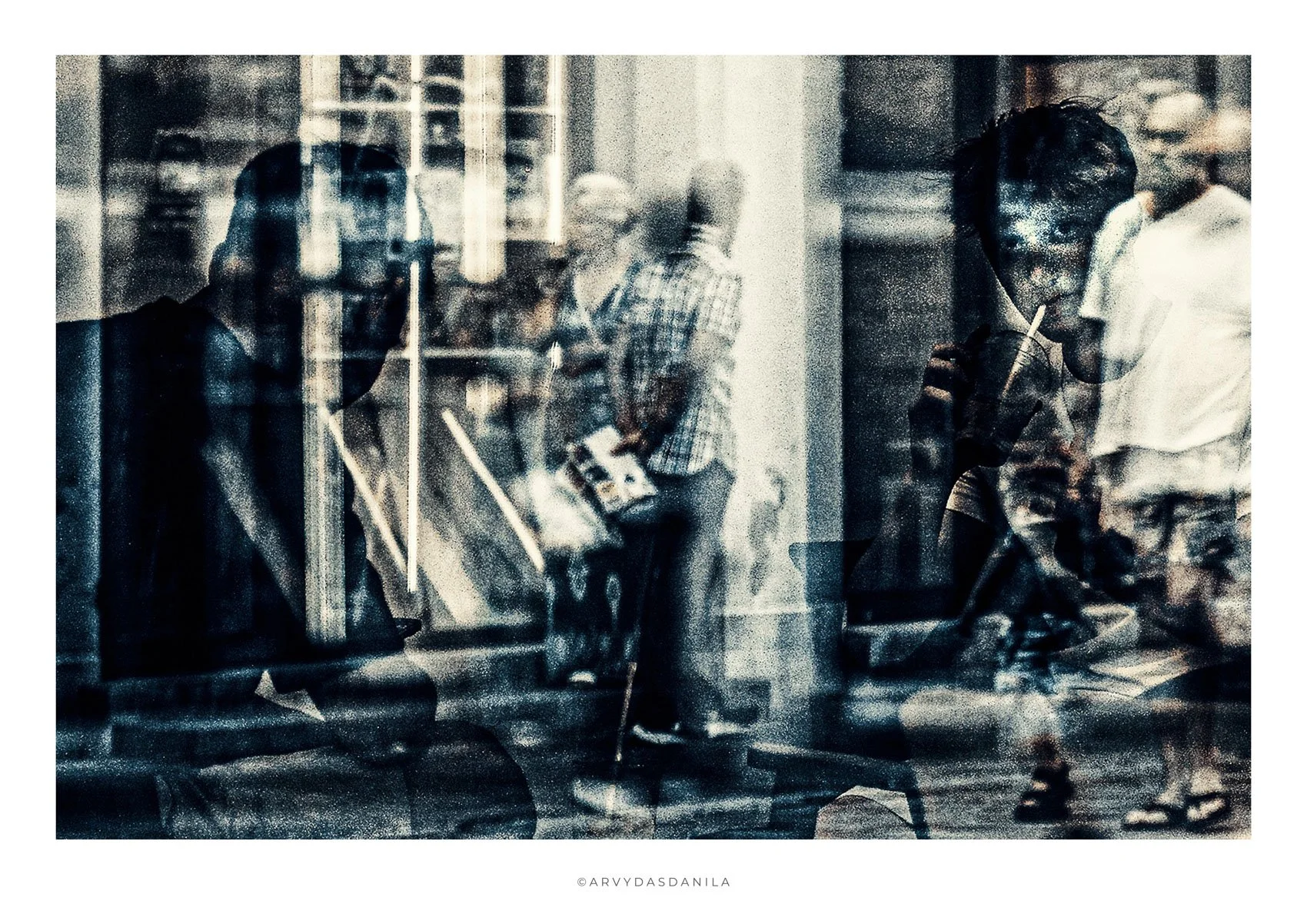 Blurred black and white photo of a group of people, some wearing masks, behind a glass window or partition, with reflections and overlapping images.
