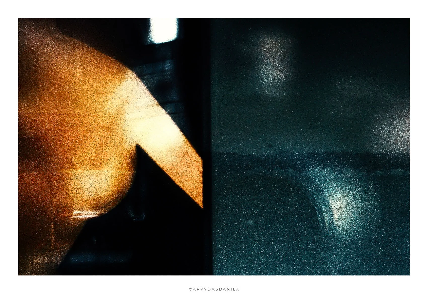 Close-up of a copper-colored, dome-shaped object on the left side, casting light onto a dark, textured surface on the right side, with a central dividing line. The image has an abstract, artistic feel.