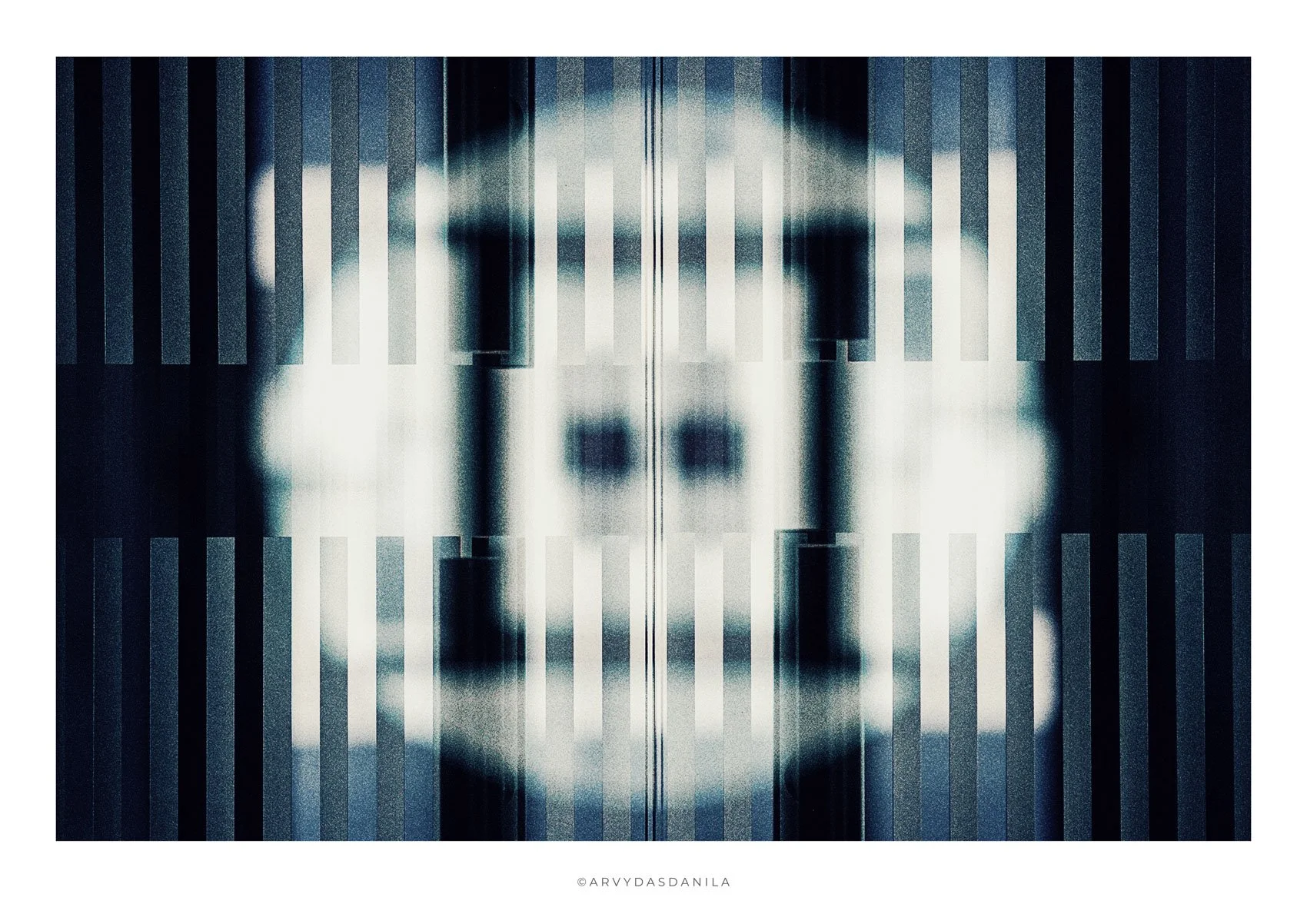 Abstract black and white symmetry artwork resembling a mirrored pattern with vertical light and dark stripes, creating geometric shapes.