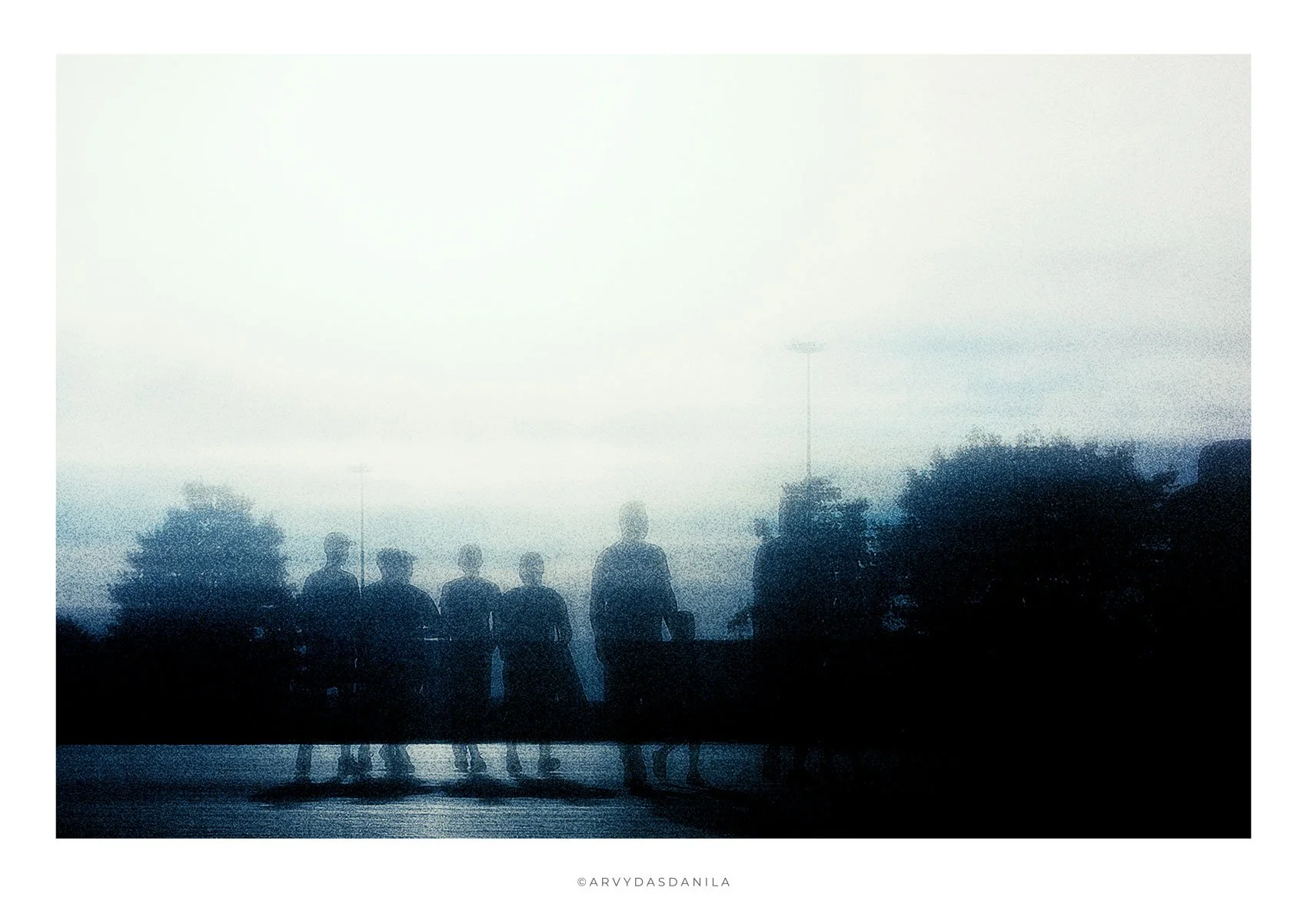 Silhouettes of people walking outdoors in a unique and visually impressive photograph, blue black and white dreamlike mystic feeling provoking questions.